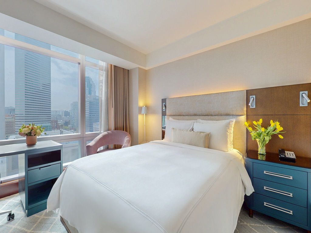 Guestroom with double beds, ambient lighting, and large windows 