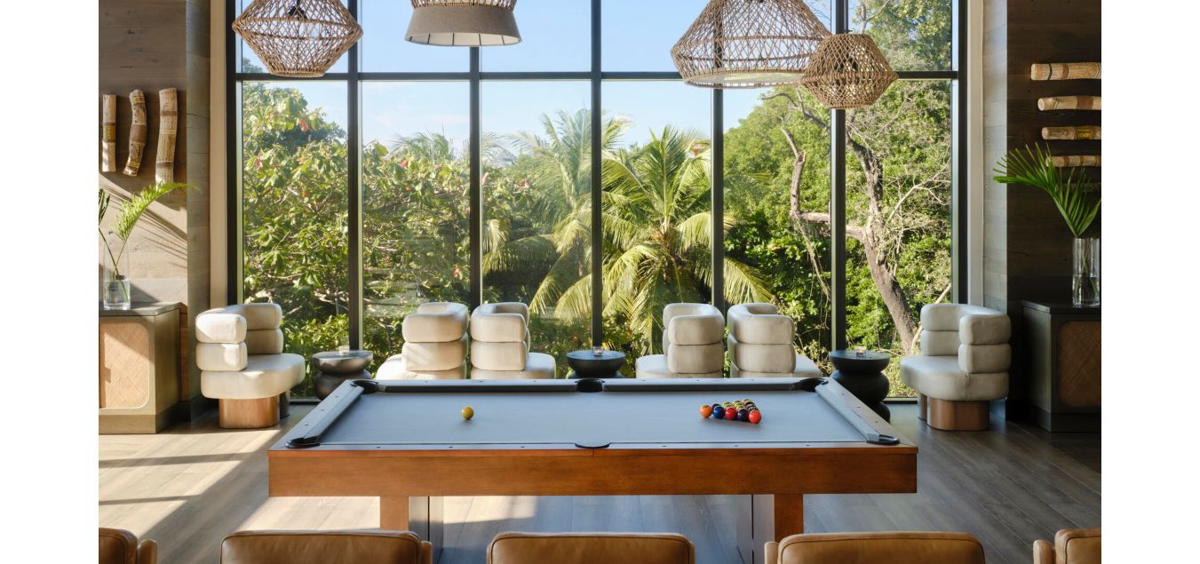 台球桌搭配时尚餐椅，透过摩登落地窗将郁郁葱葱的热带风情尽收眼底