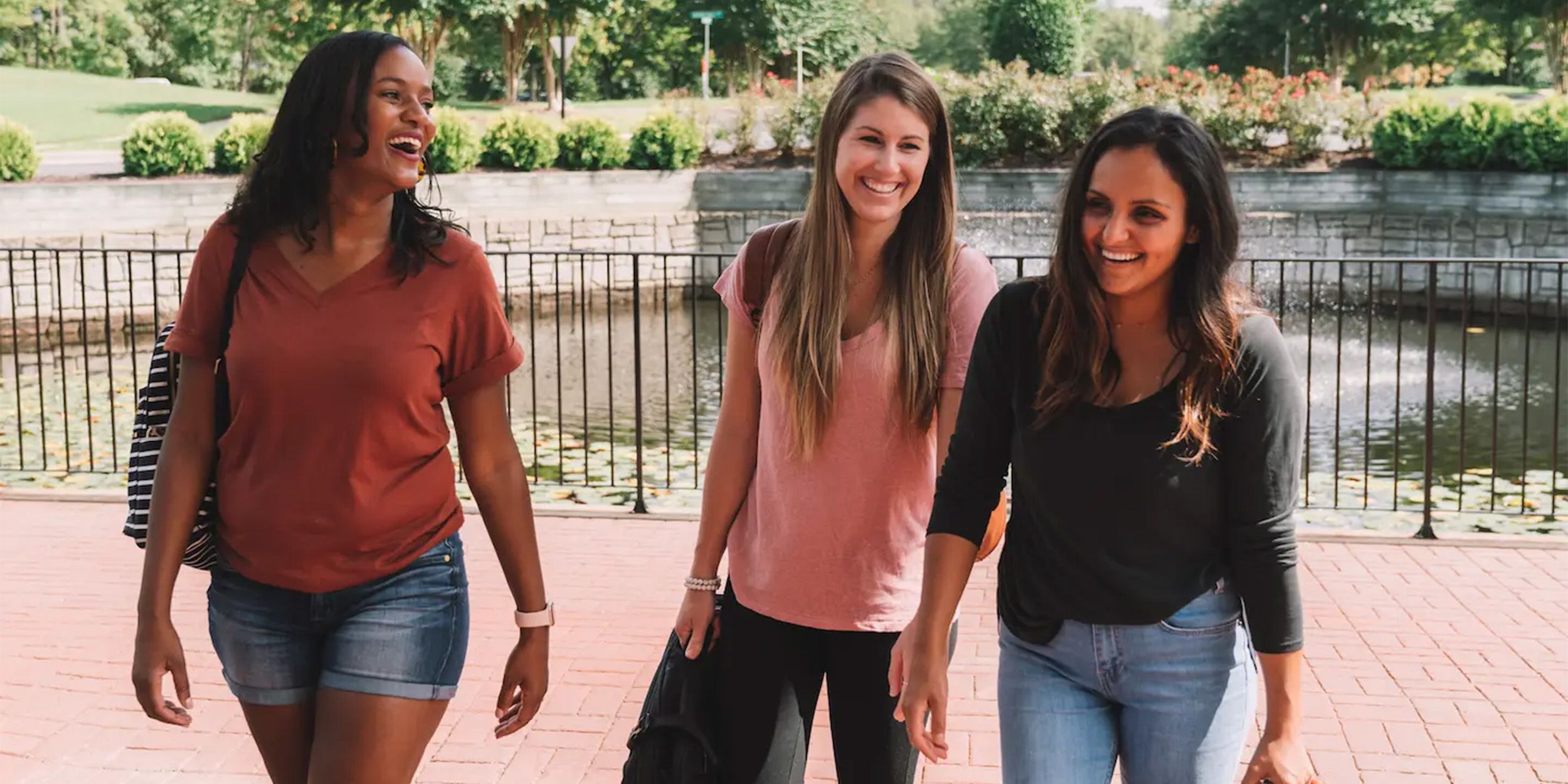 Three women laughing outside