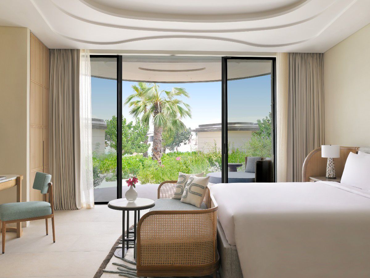 Elegant hotel room overlooking tropical garden.