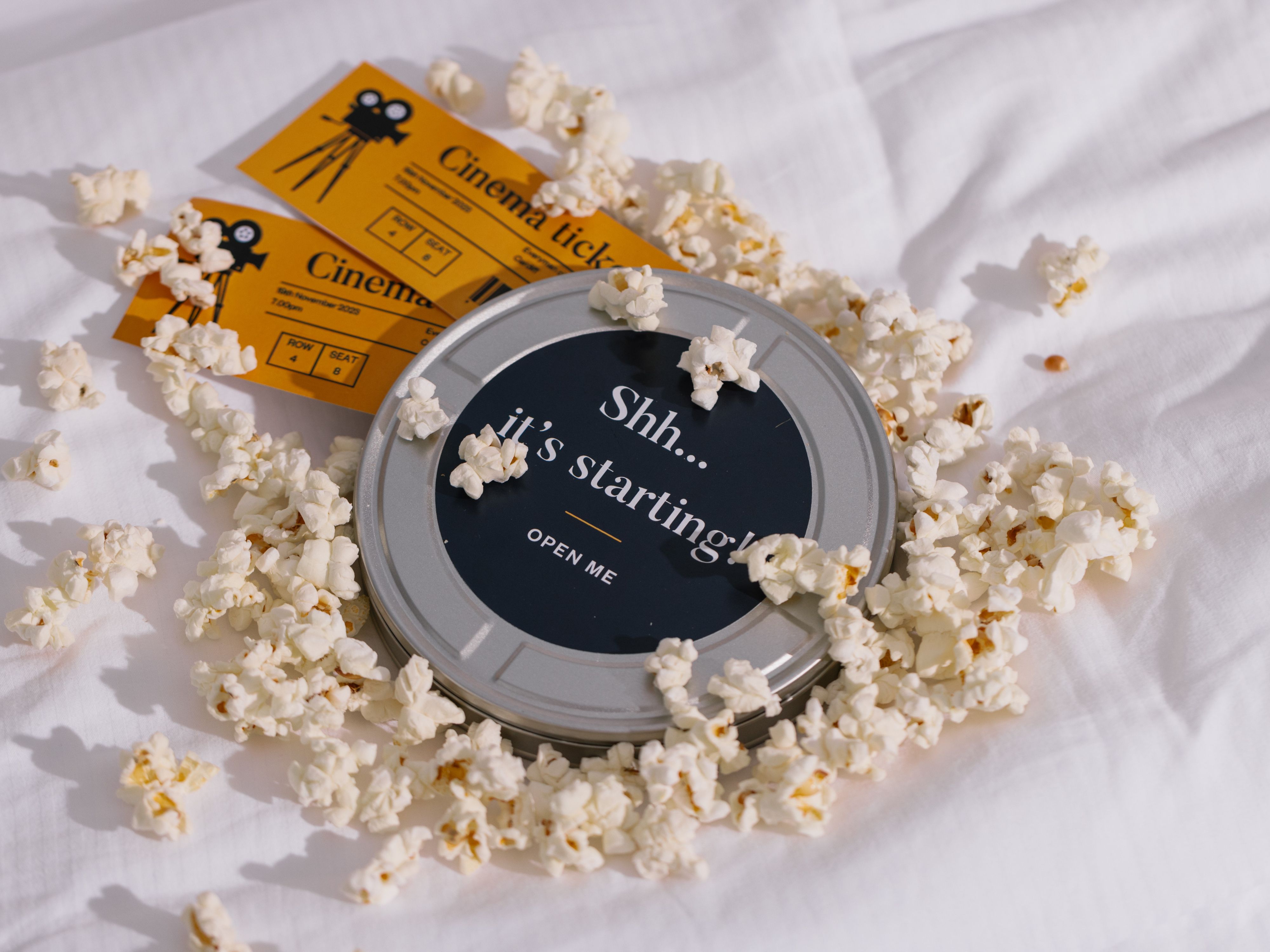 Popcorn snack and movie tickets on hotel bed