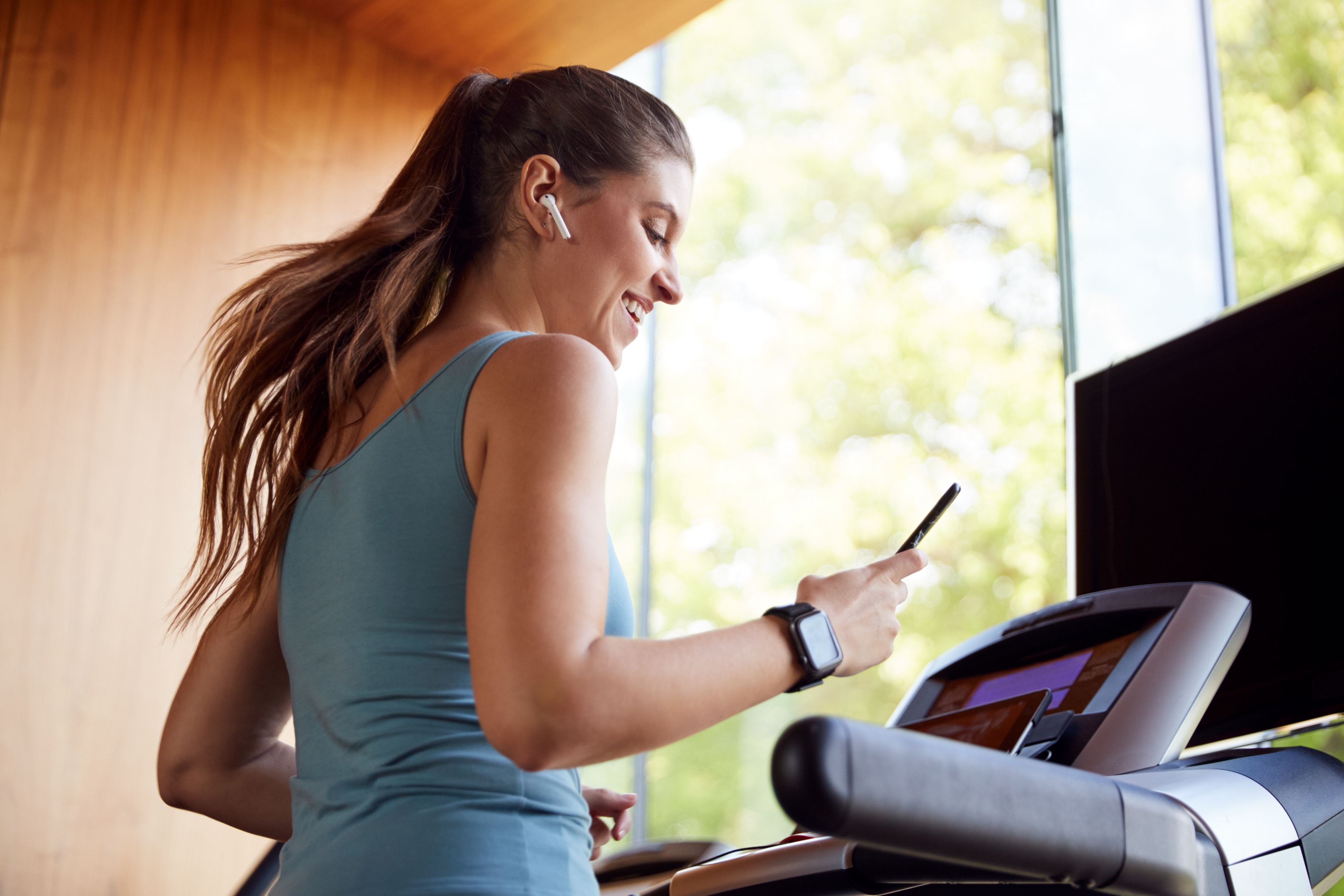 Guest in sportswear runs on a treadmill and is surrounded by other training equipment in the hotel's fitness center