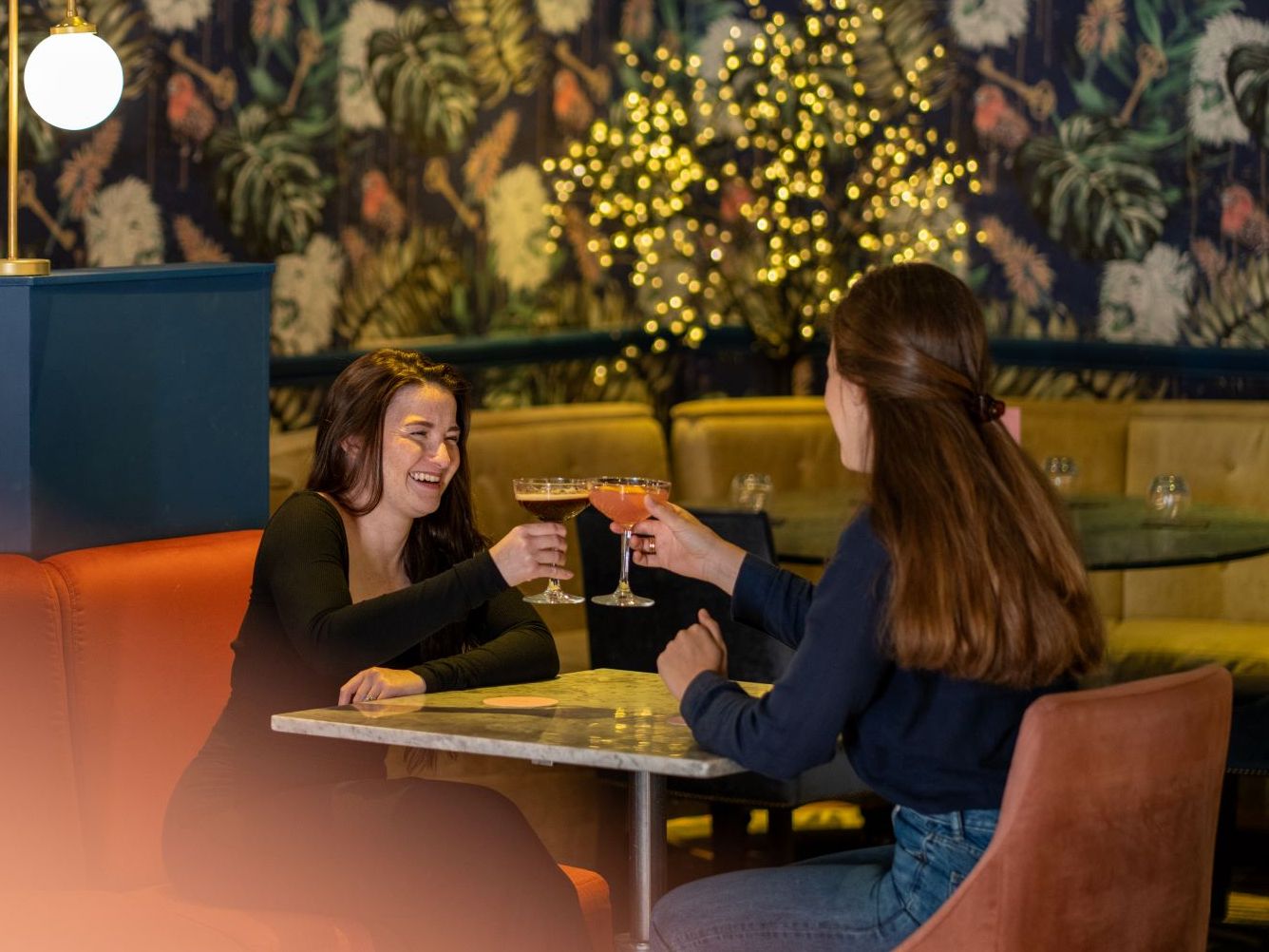 Two women toasting with cocktails