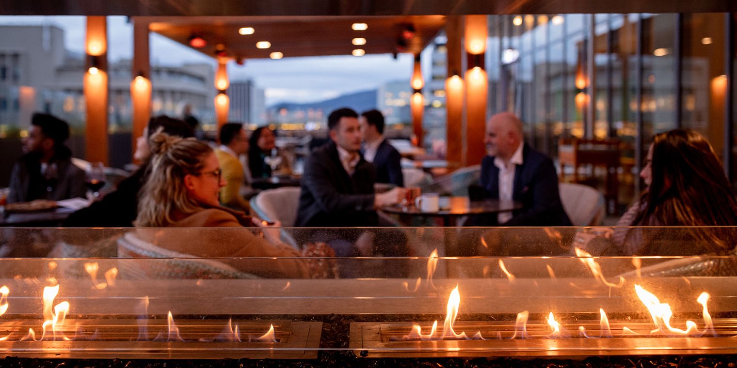 patrons at The Deck by the fire at night
