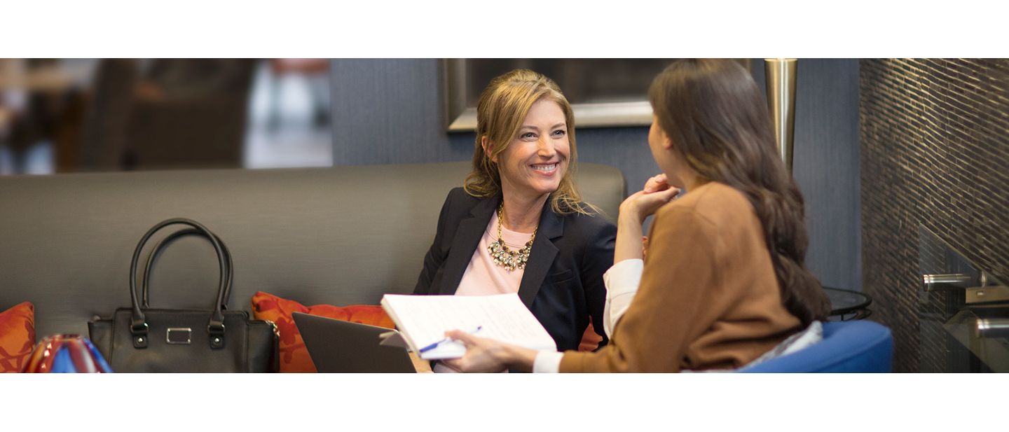 Two women talking in a hotel lobby