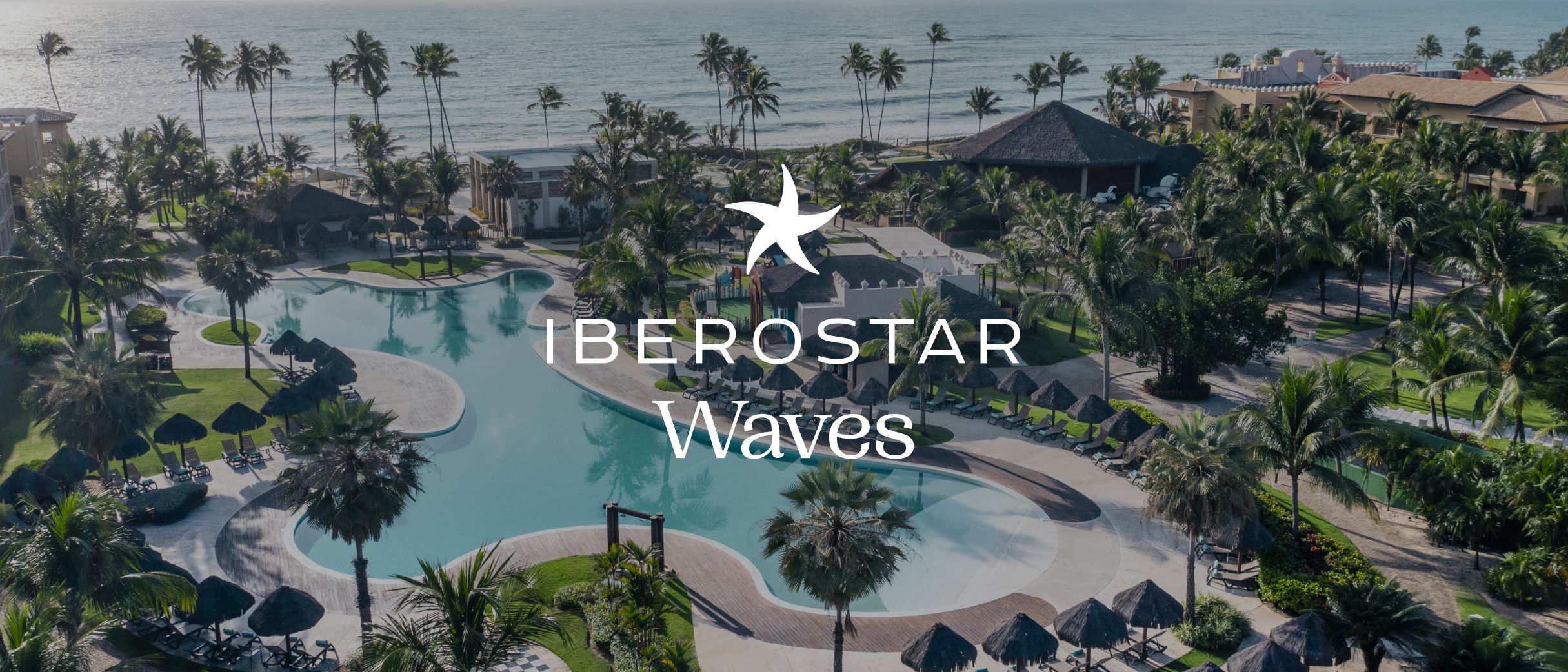Iberostar Waves 度假村内，泳池碧波粼粼，四周环绕着郁郁葱葱的热带园林。