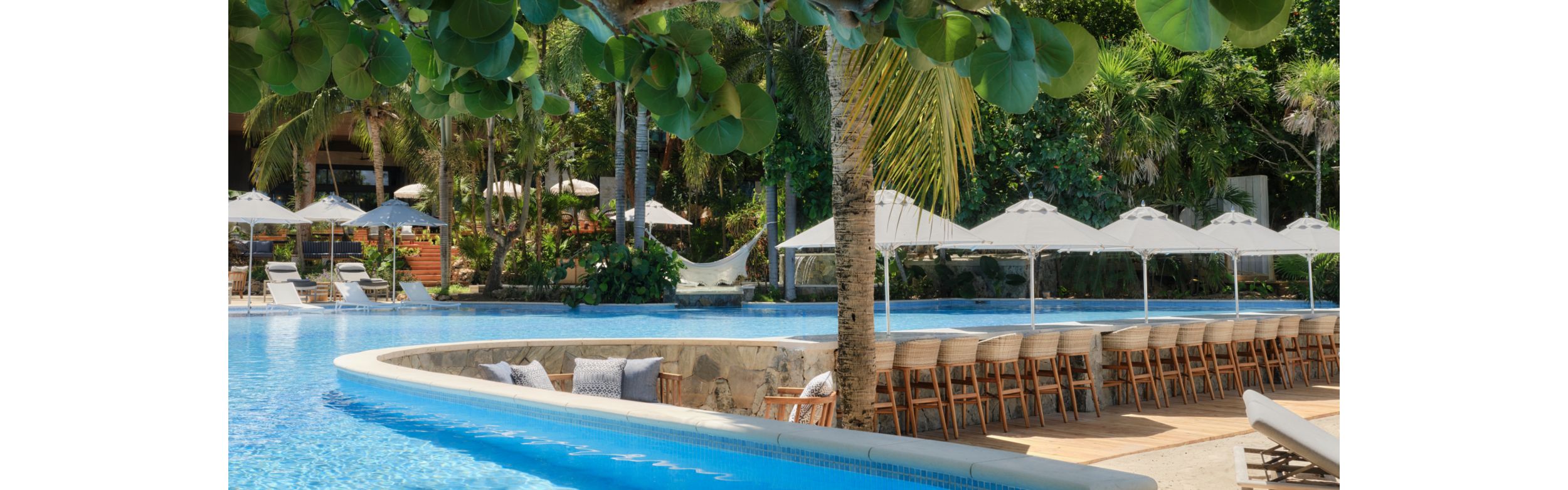 波光粼粼的户外泳池和配备遮阳伞的躺椅