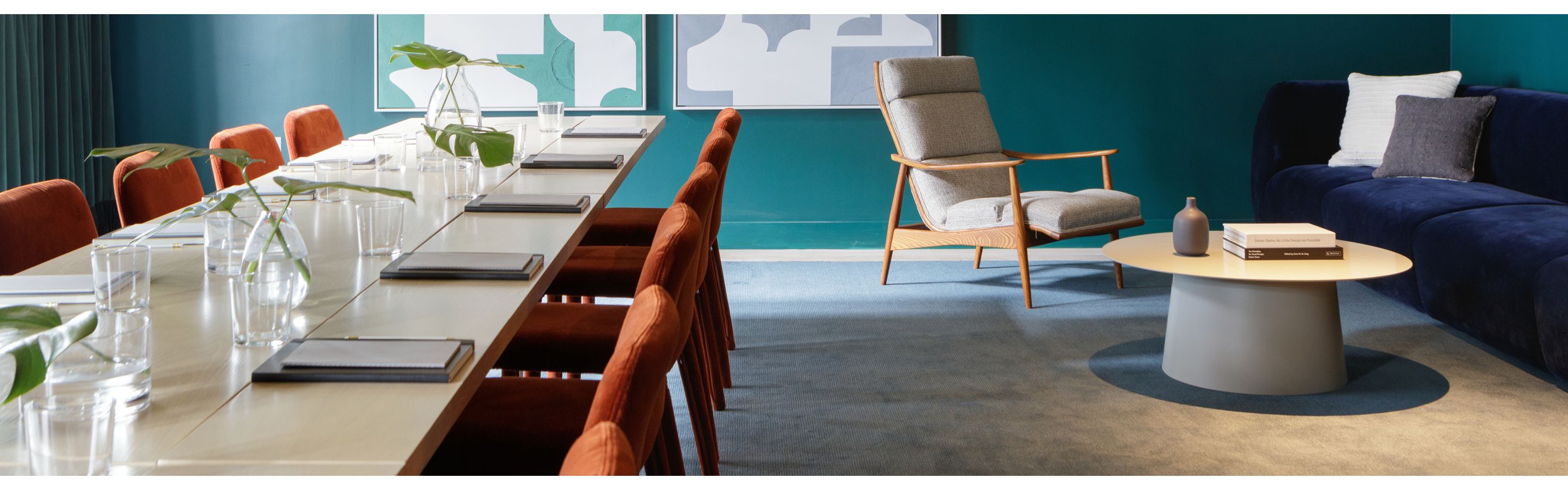 large meeting room with plush seating and pellegrino water bottles
