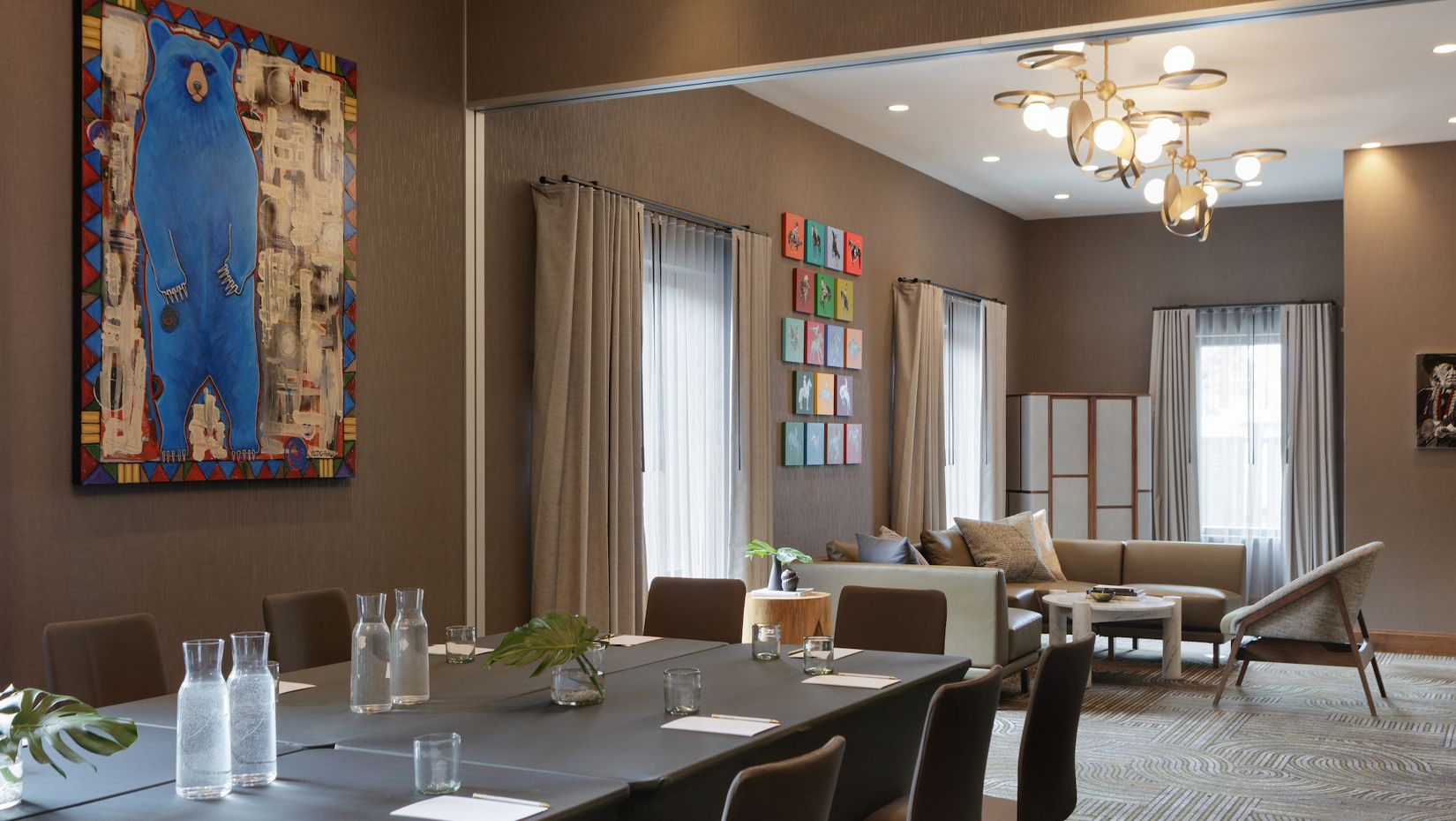 会议室配备饮用水，墙面装饰有色彩丰富的艺术作品