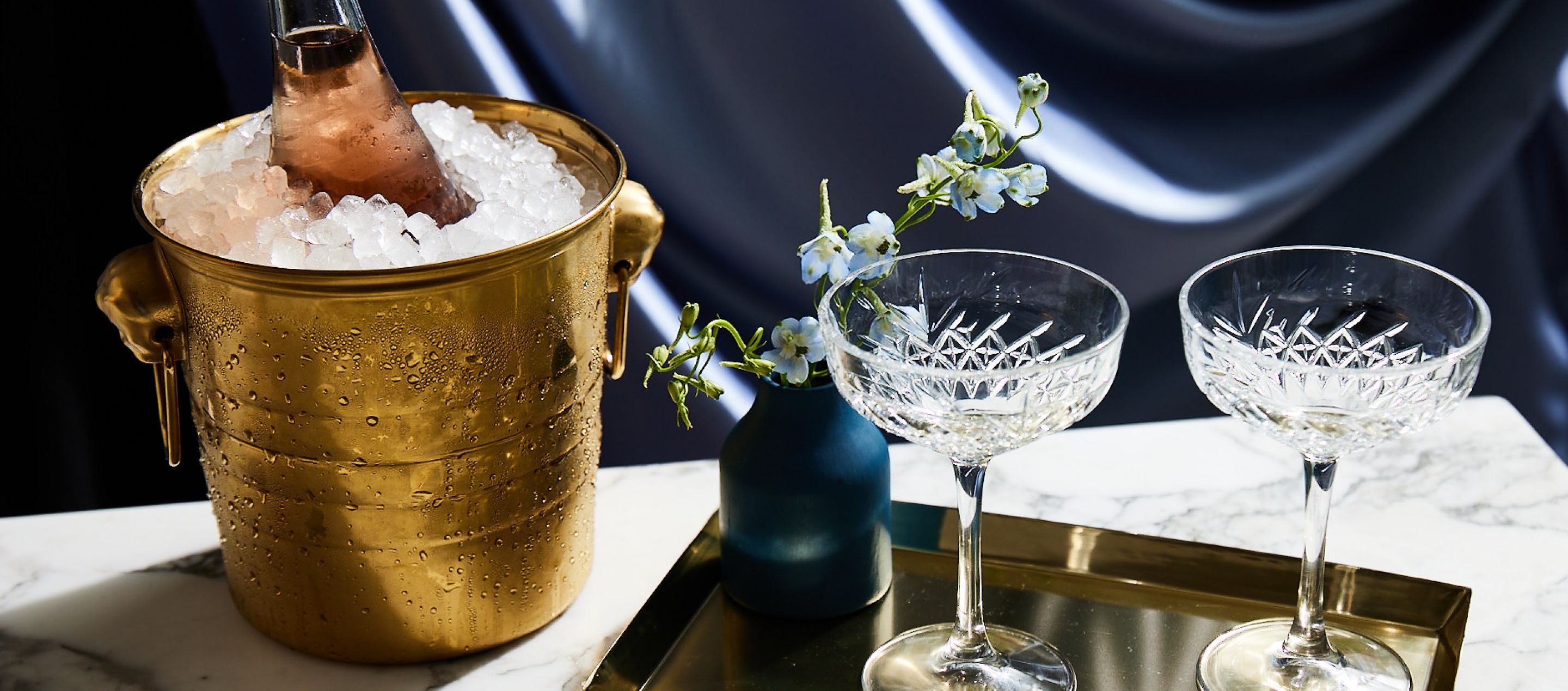 两个装满气泡酒的香槟酒杯和一个玻璃糖果罐的特写