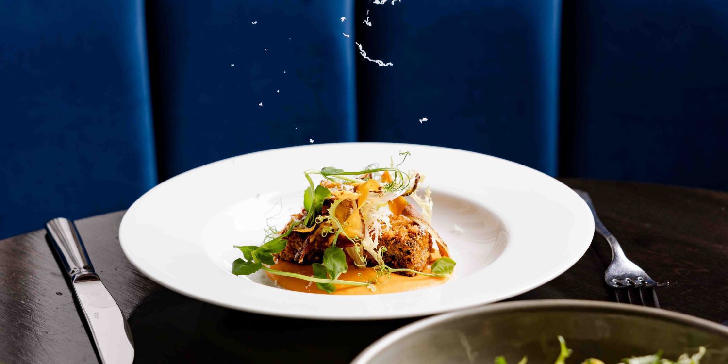 Grating parmesan onto aranchini dish