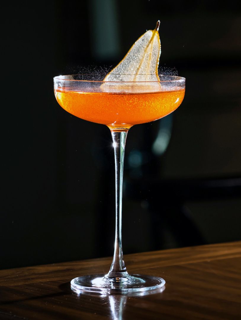 薄切梨片点缀装有气泡鸡尾酒的高脚杯