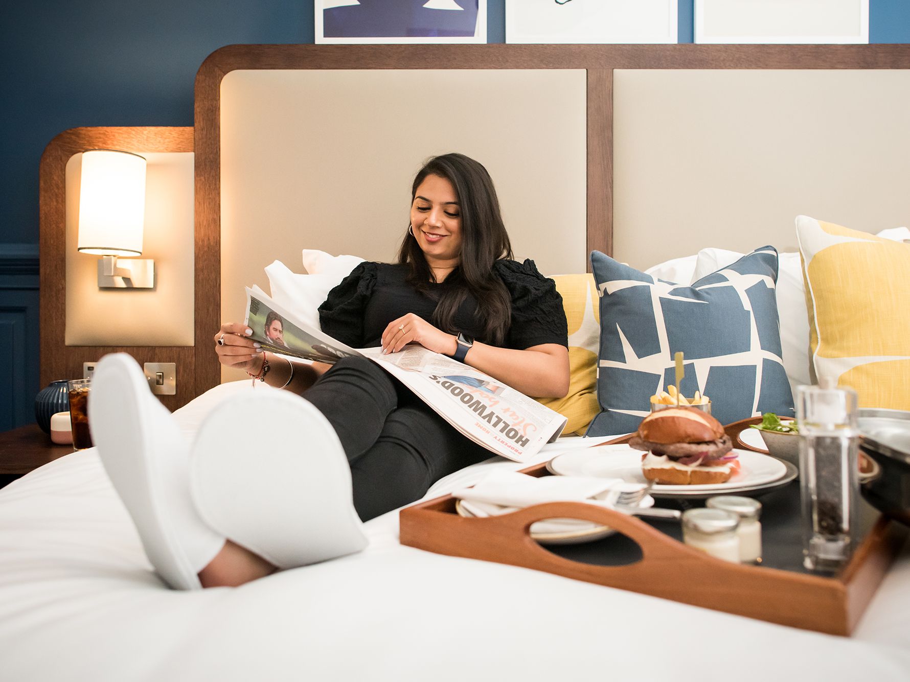 Woman reading and eating in bed