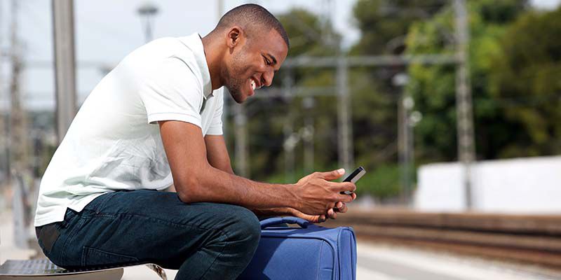 Man sitting on a bench looking at his phone