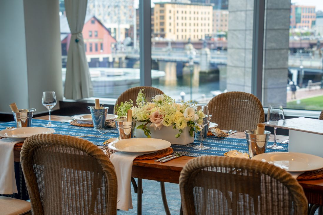 Table set for a dining event with a floral centerpiece, place settings and menus.