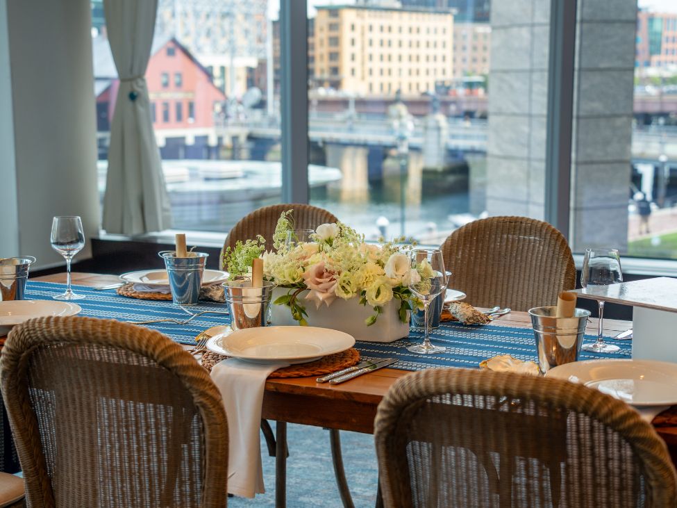 Table set for a dining event with a floral centerpiece, place settings and menus.