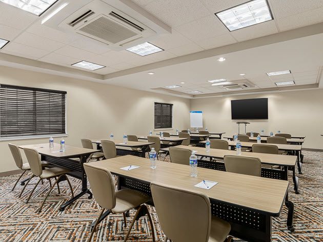 Tables and chairs in a meeting room at Candlewood Suites