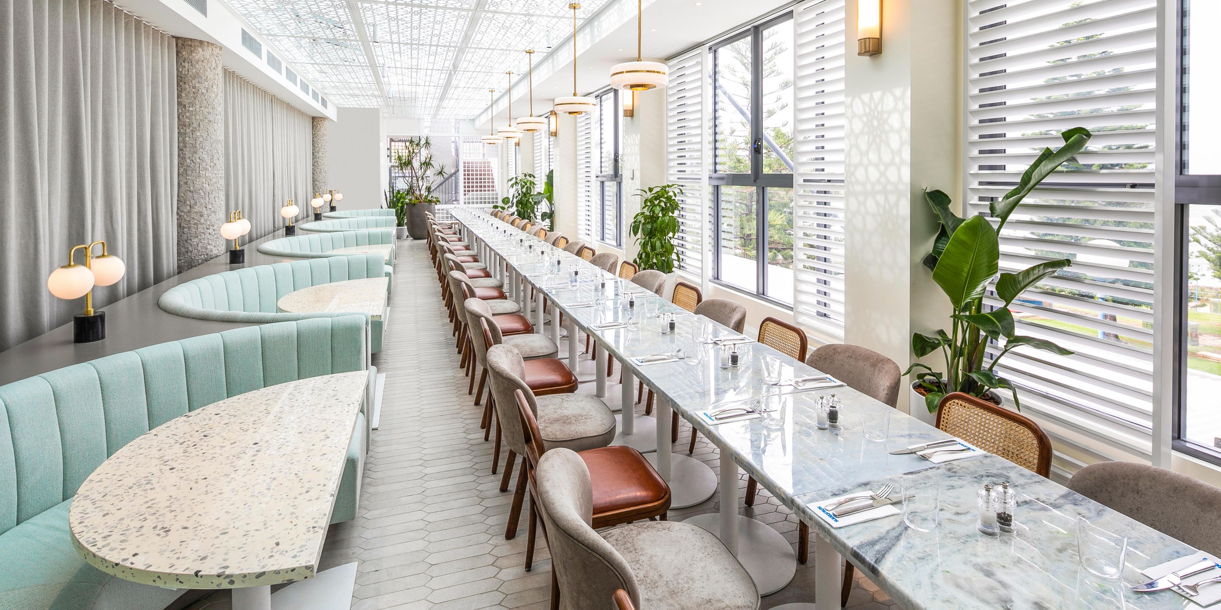 Nestled on Coogee Beach, Shutters is a captivating restaurant, bar, and function space, embracing coastal charm. Its shuttered windows frame azure waters and golden sands, offering unparalleled dining with sweeping sea views. Enjoy coffee, lunch, or evening celebrations at this elegant venue, creating unforgettable moments for all.