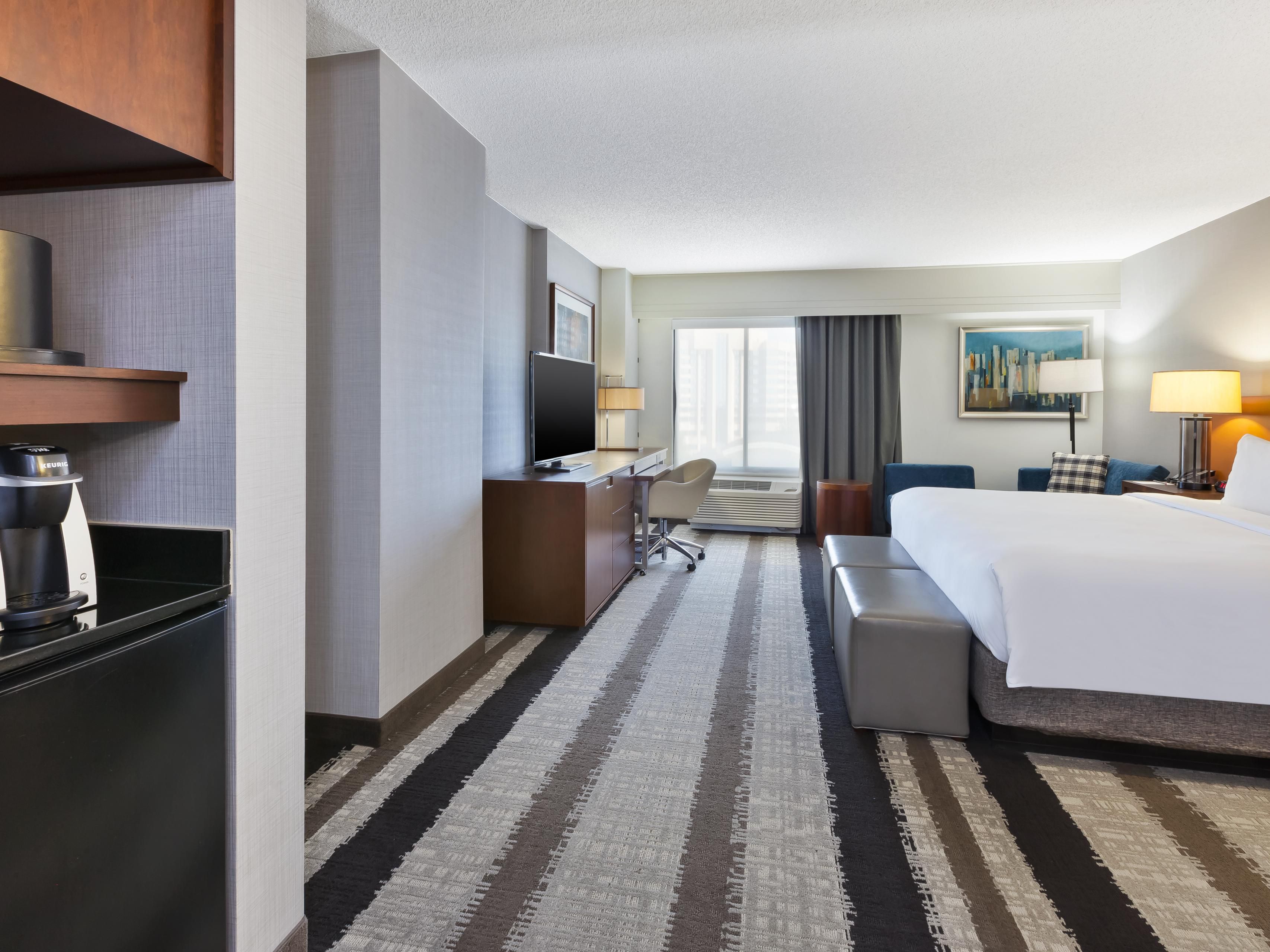 Our luxurious hotel rooms offer plenty of space for you to relax and rejuvenate. With plush bedding, a large desk and ergonomic chair, a lounge area, and sparkling-clean bathrooms, you’ll want for nothing. If you plan to bring your canine companion along, we’ll provide a bed and amenities for your furry friend, too! 