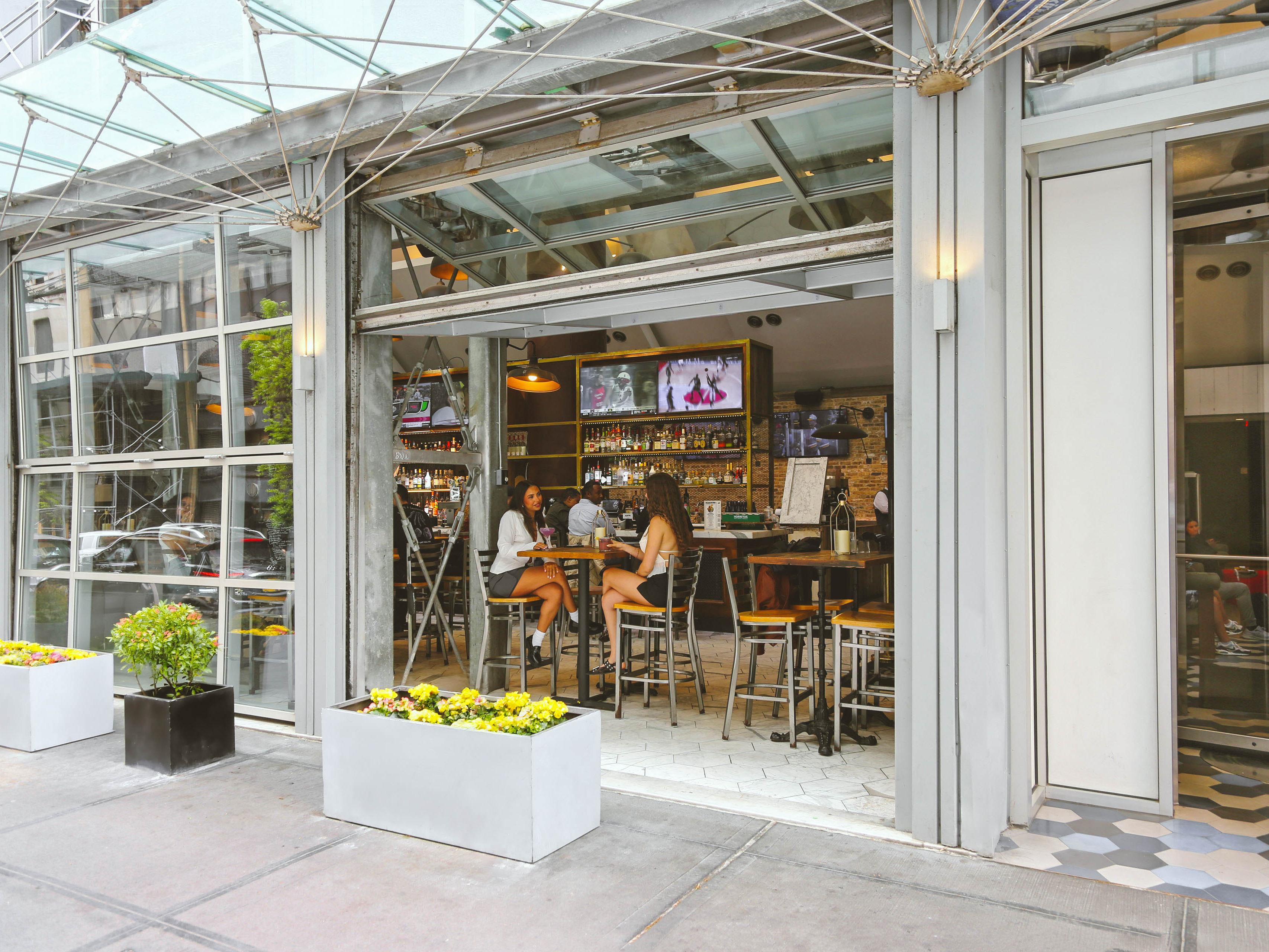 Burgerology Midtown boasts a vibrant atmosphere with soaring 80-foot ceilings, cascading chandeliers, and glass garage doors, creating a modern yet inviting space. Friendly, attentive staff serve exciting cocktails, making it the perfect spot to enjoy gourmet burgers and a lively dining experience.