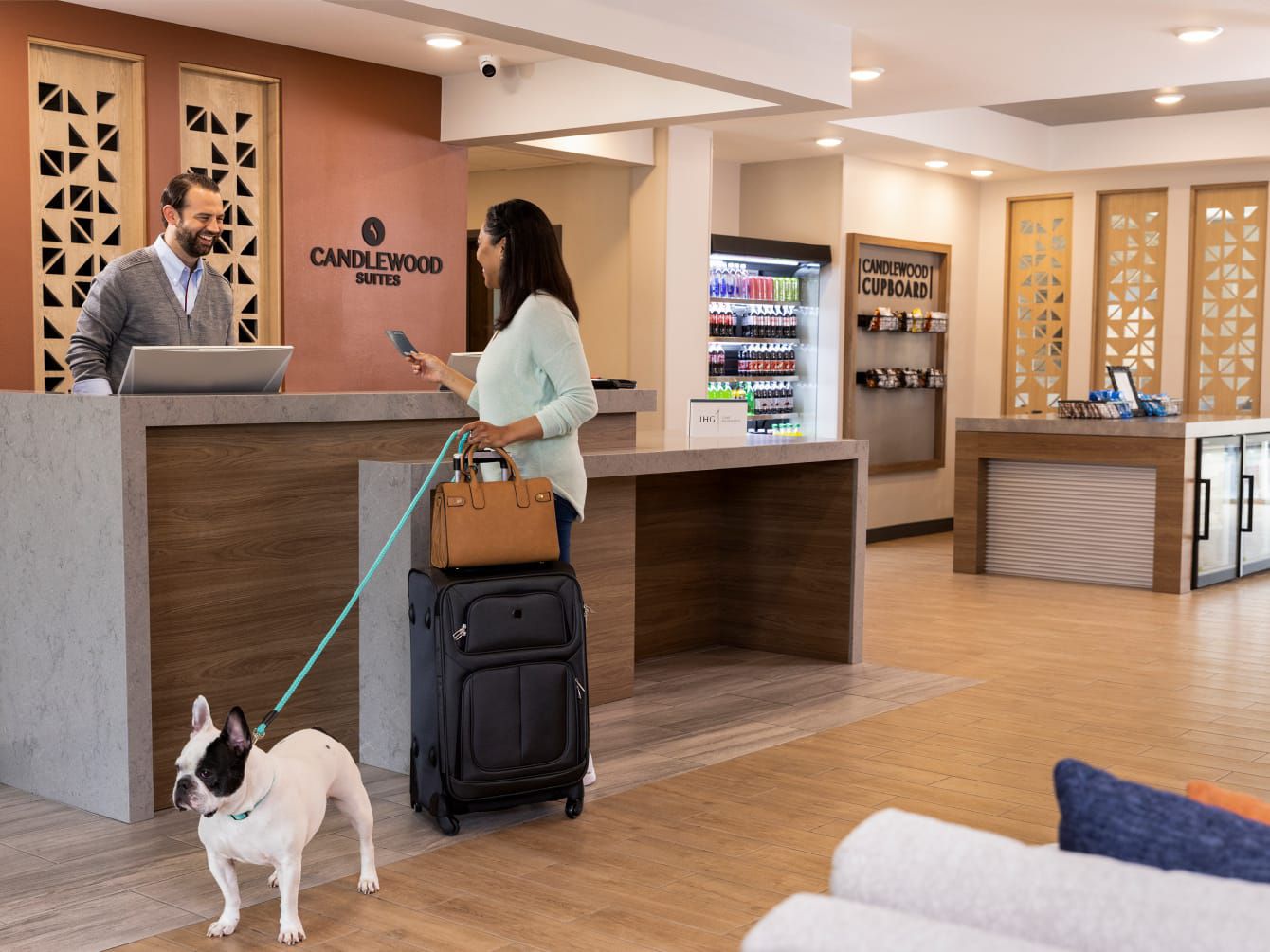 Woman checking in at front desk with dog