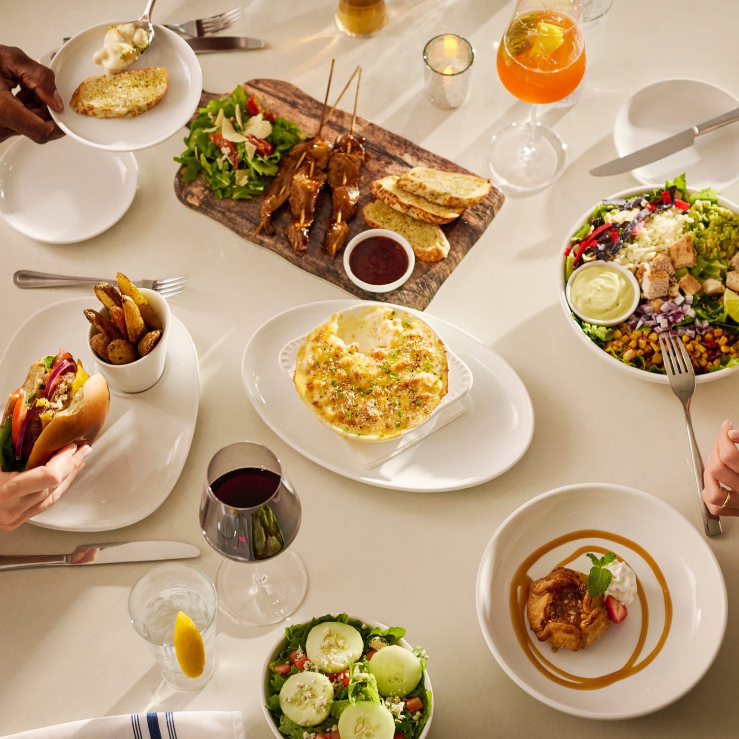 A table filled with delicious dishes including salad, sandwiches, chicken and dessert.