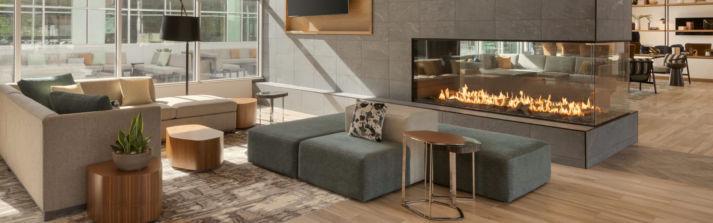 Modern lobby with comfortable seating and a statement fireplace dividing the room.