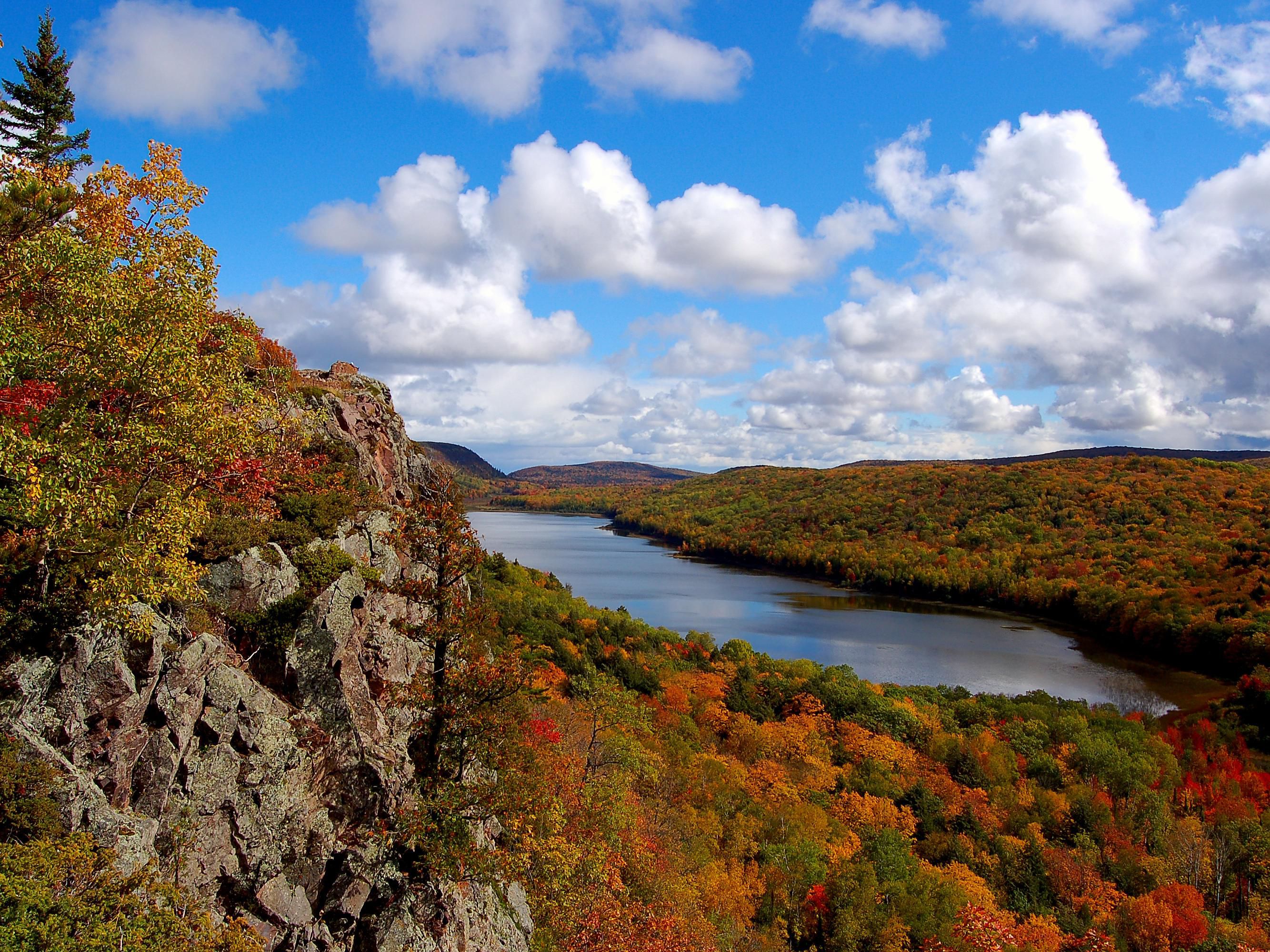 Wide view of a forest in autumn with a lake in the middle