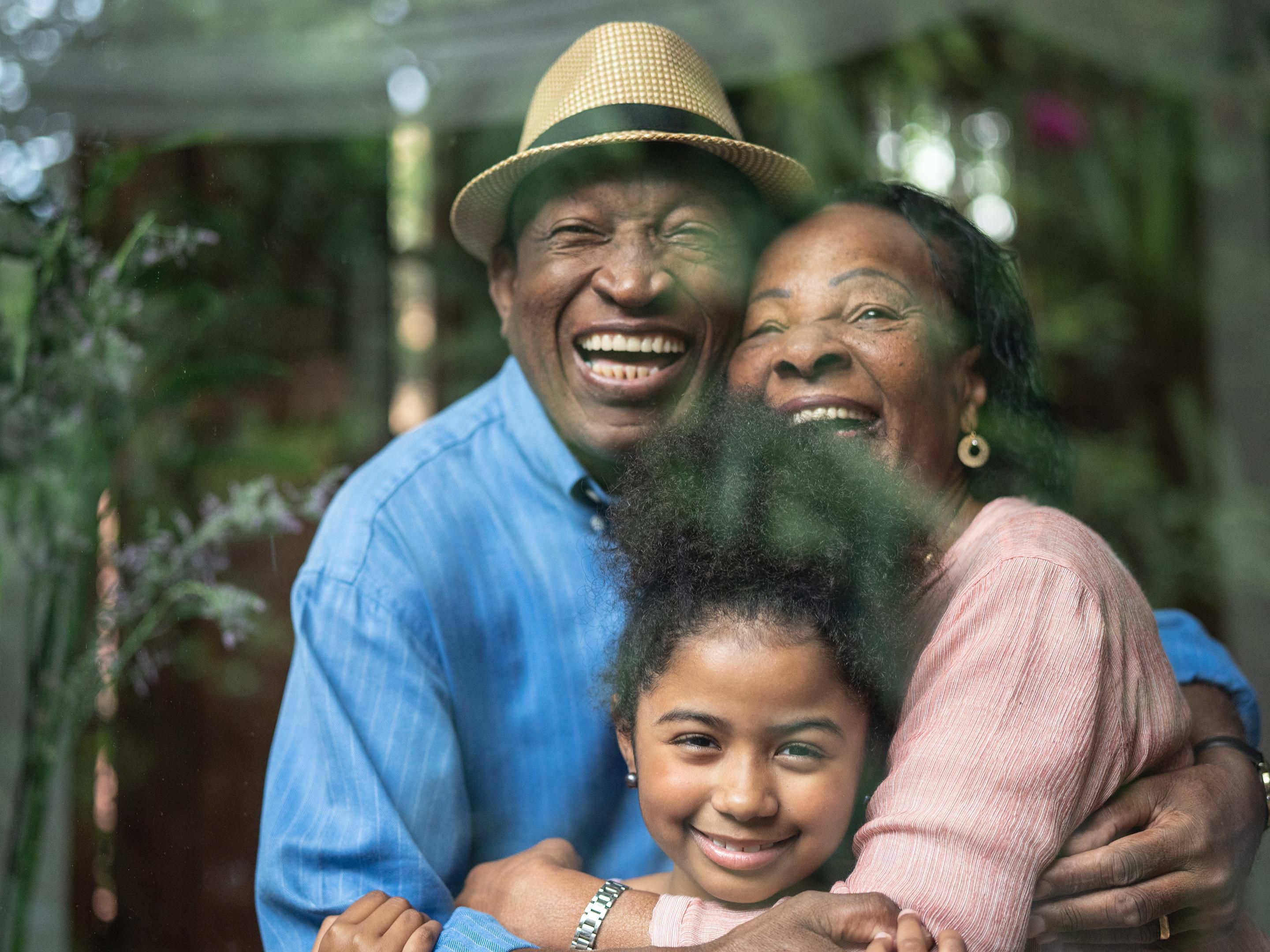 Grandparents hugging their grandchild