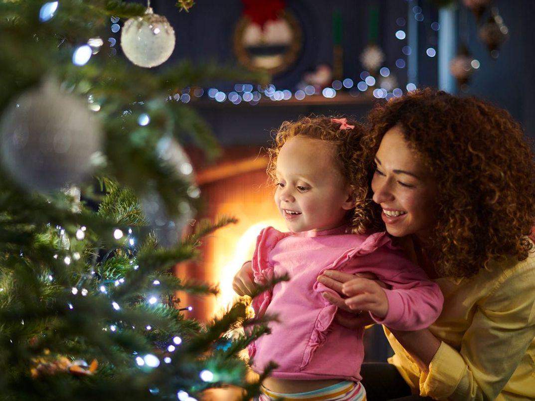 Mum and daughter decorating a christmas tree