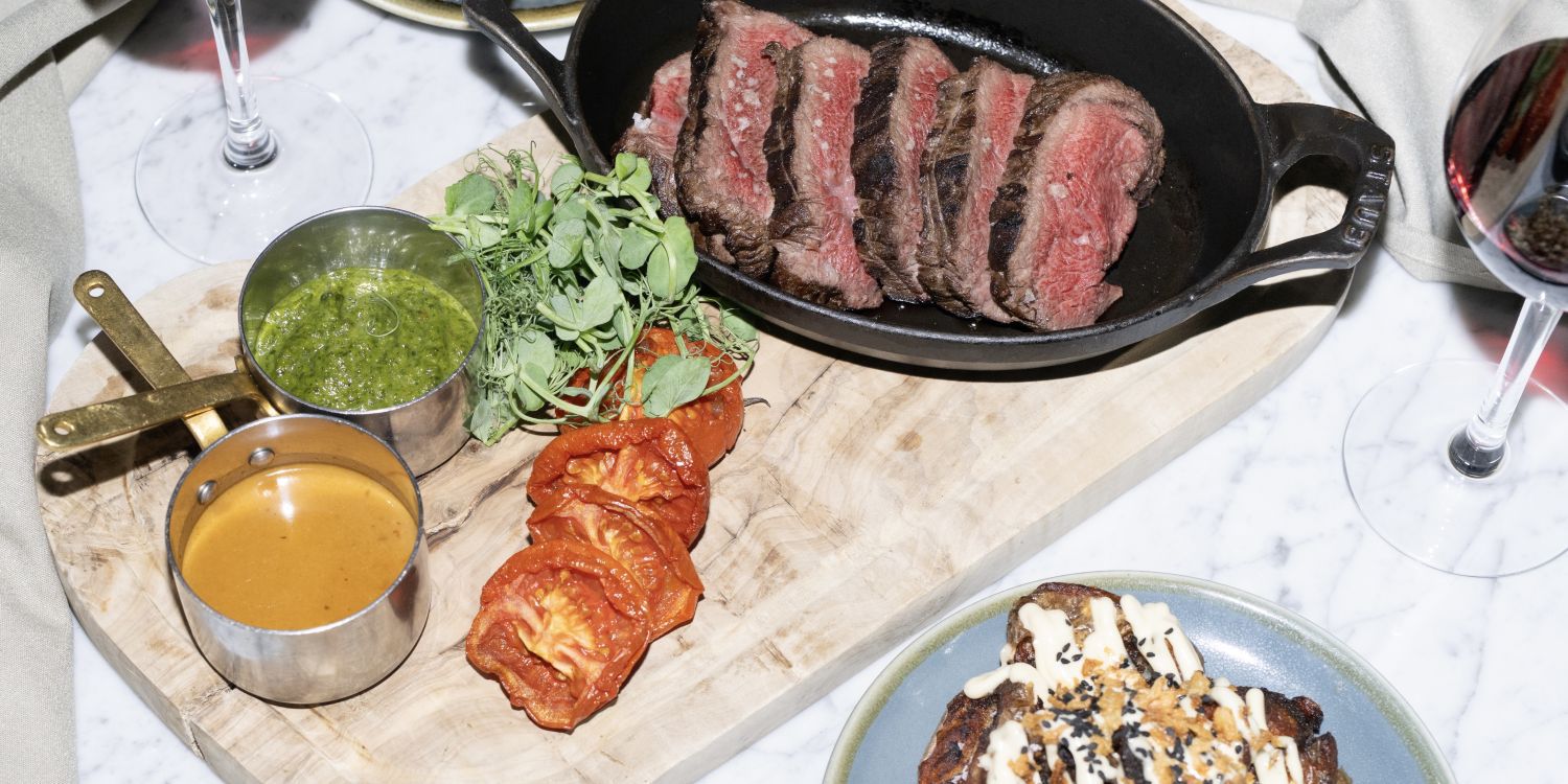 steak dinner with sauces, sides and red wine