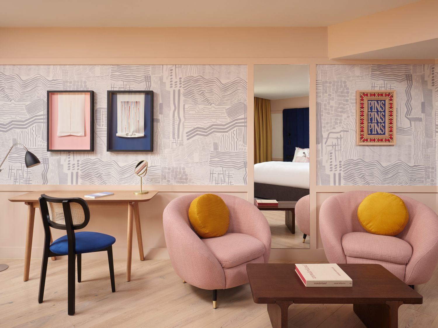 room interior featuring pink plush chairs, a working desk and wall prints