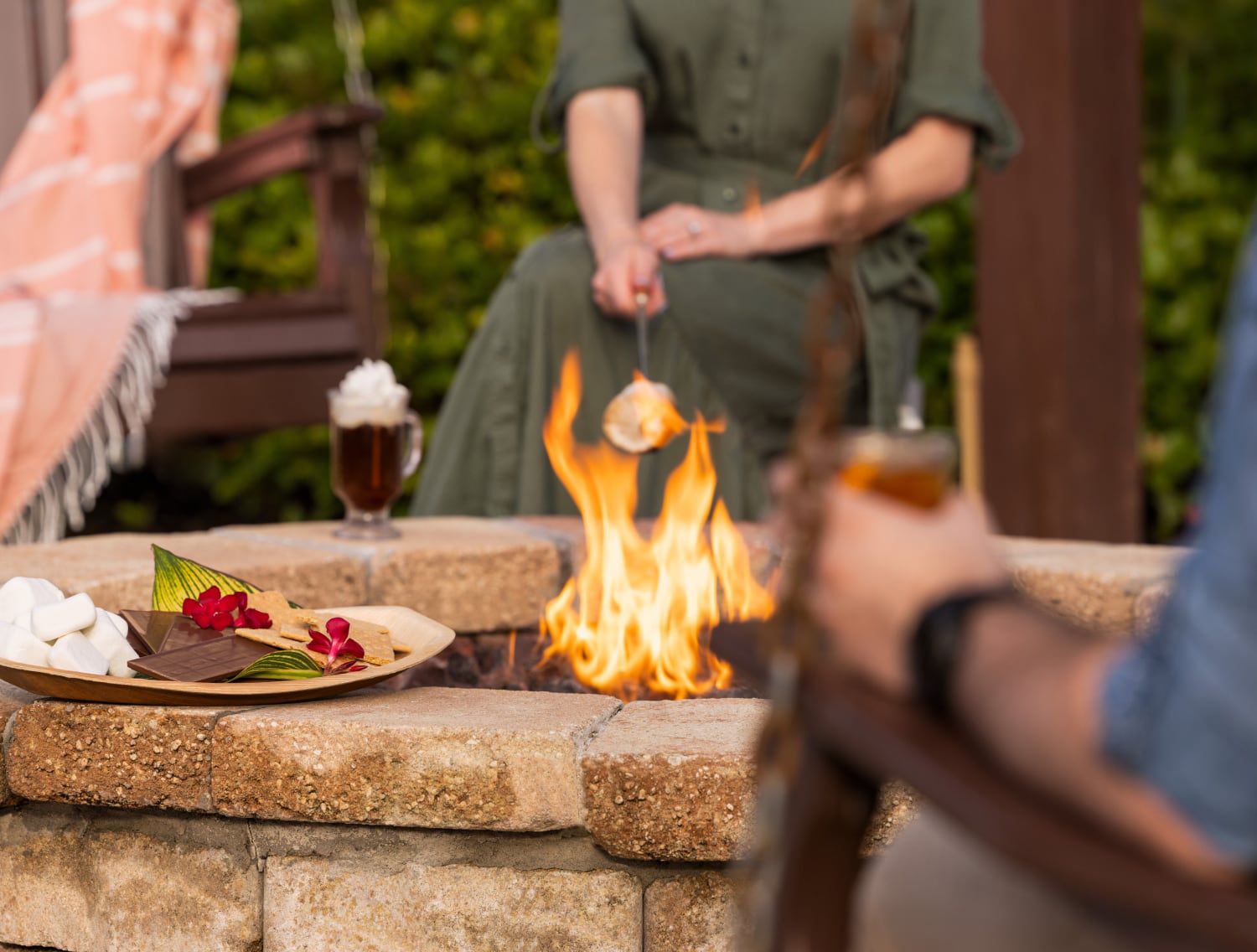 人们围坐在篝火旁烤棉花糖