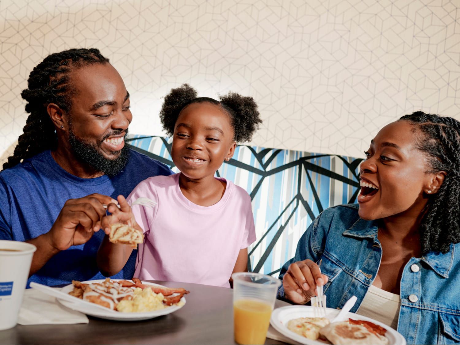 Family laughing and enjoying breakfast together at a table