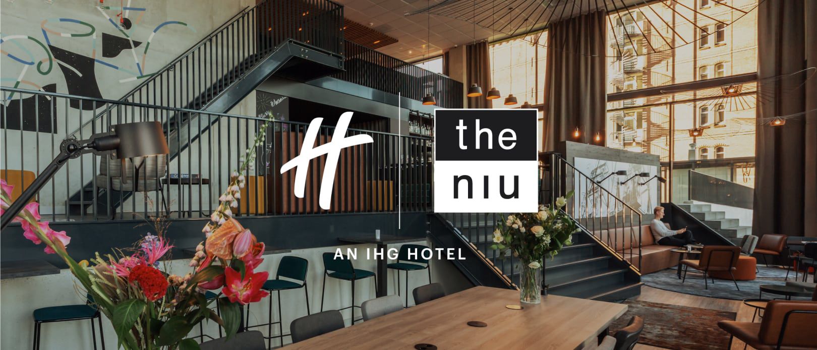 the niu 假日酒店标志与现代大堂交相辉映，营造出明亮温暖、宾至如归的氛围。