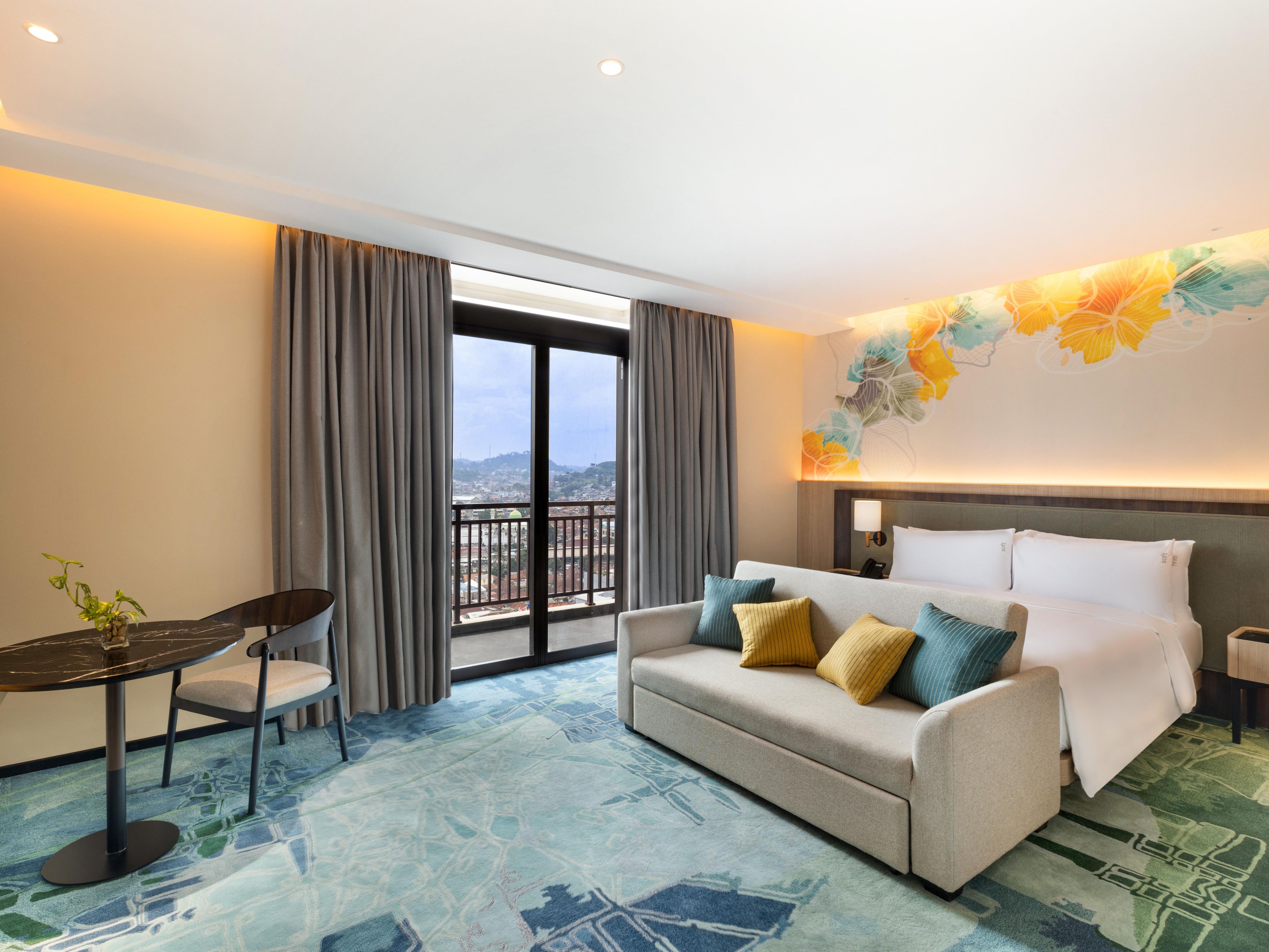 Our rooms offer a blend of modern elegance and comfort, featuring private balconies with stunning views, plush bedding, flat-screen TVs, and high-speed internet.  Enjoy the panoramic city vistas from our outdoor pool or savor the flavors of local and international cuisine at our dining venues, complemented by refreshing cocktails.