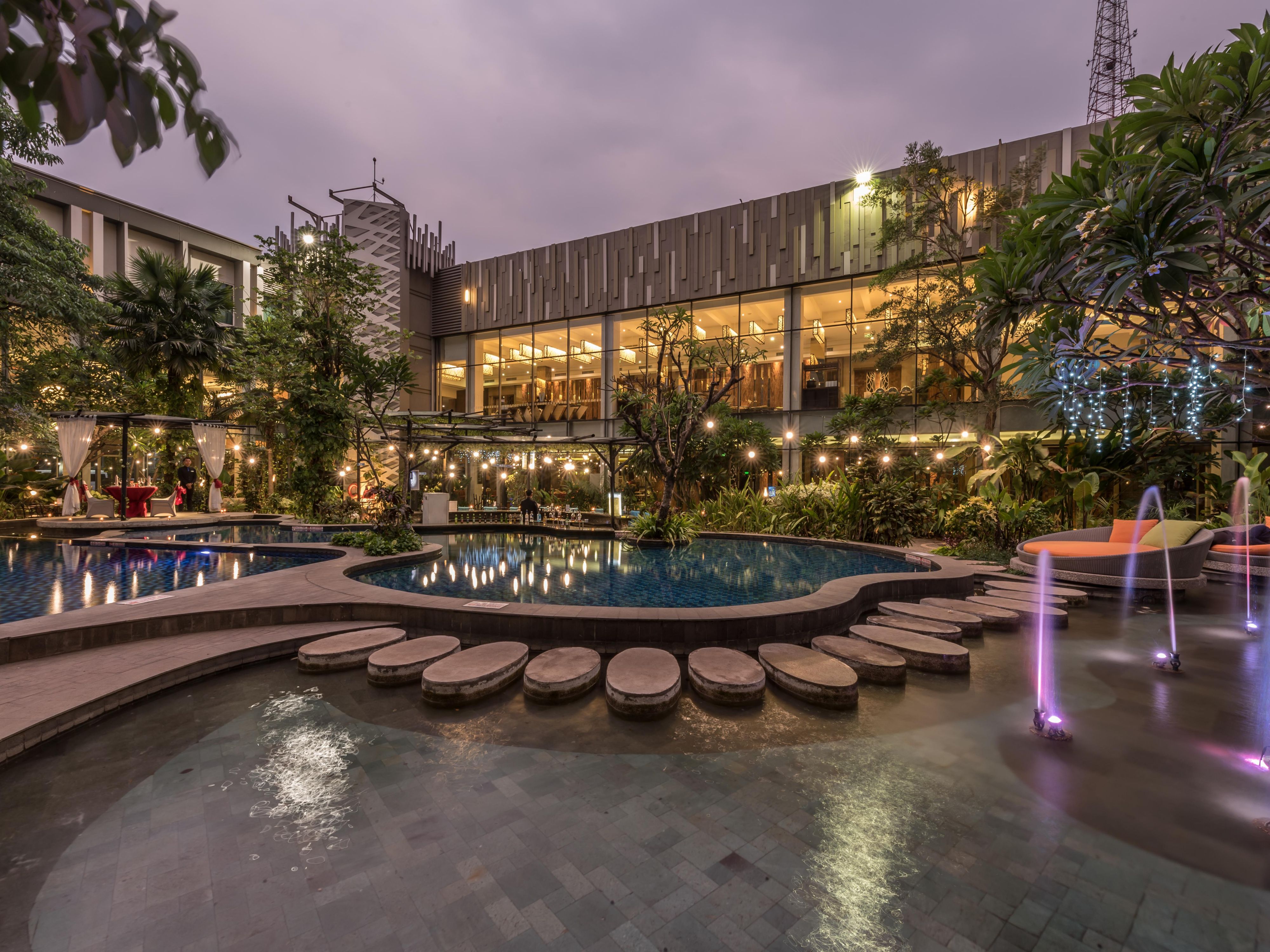 这个度假胜地风格的游泳池为每位游客提供了绿色清新的空气，装饰有多种植物和各种游泳池