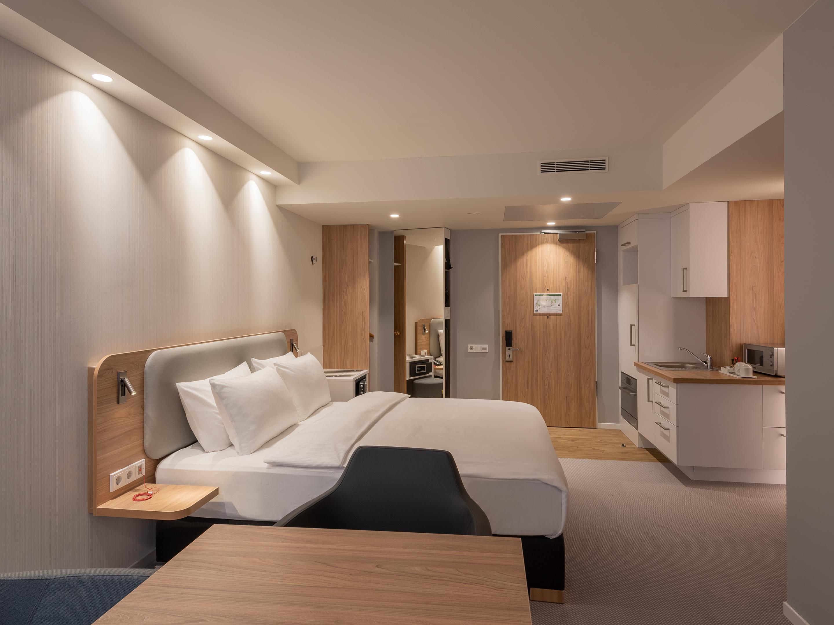 Air-conditioned Next Generation bedrooms feature premium bedding, blackout curtains, USB charging points, and an ergonomic workspace. Suites include kitchenettes and refrigerators, perfect for extended stays. Enjoy complimentary tea and coffee, free Wi-Fi, a Smart TV, and more.