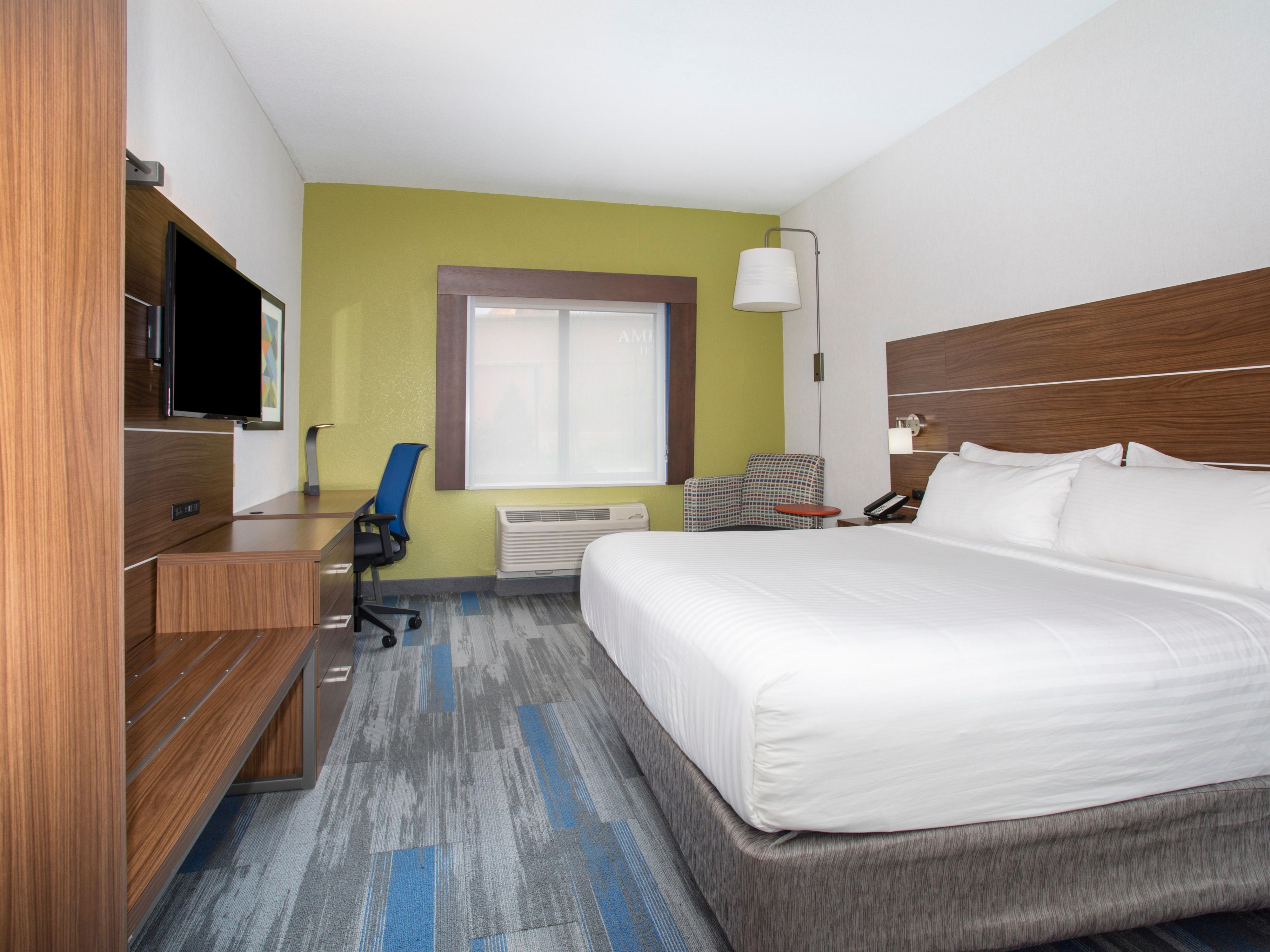 King Guest Room with a Cozy Chair and Well-Lit Work Desk