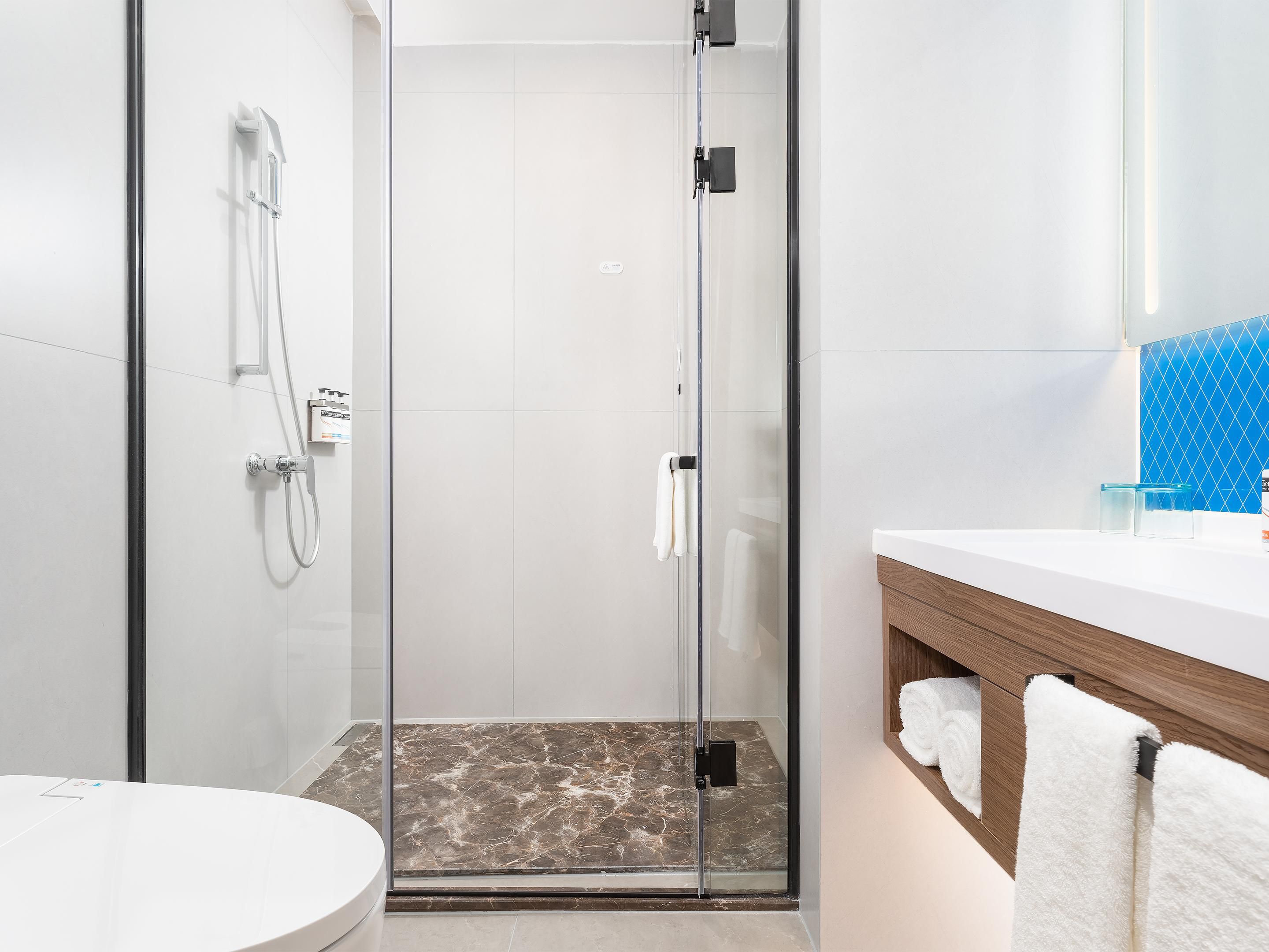 酒店客房配备：智能语音助手（小度），智能马桶，步入式淋浴间干湿分离，一键式屏幕投影，所有房间落地窗，窗户是双层隔音玻璃。床垫是金可儿，房间有熨衣板。