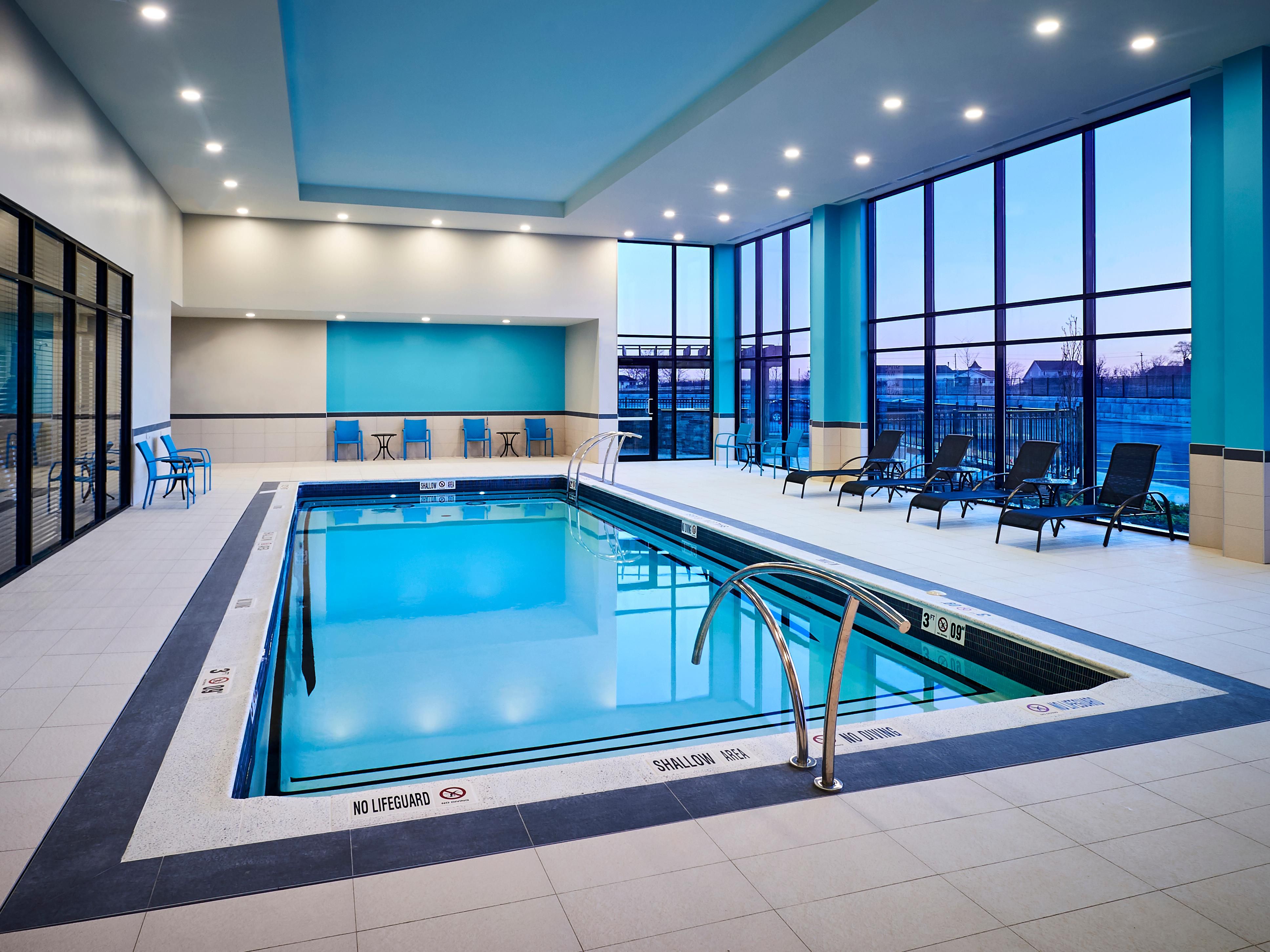 Swim in our indoor pool with lounge chairs and big windows.