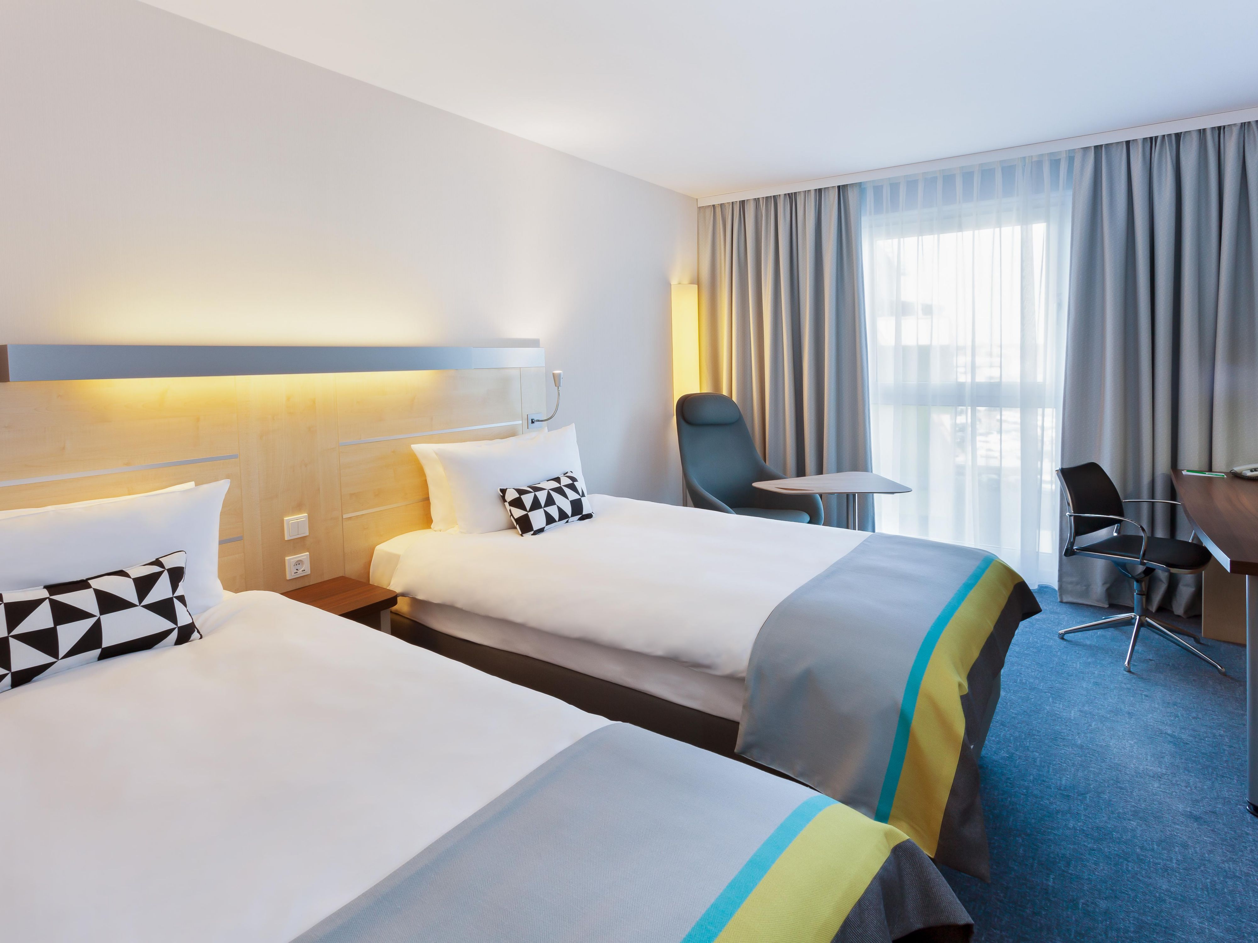 Guest bedroom featuring a large window and a workspace.