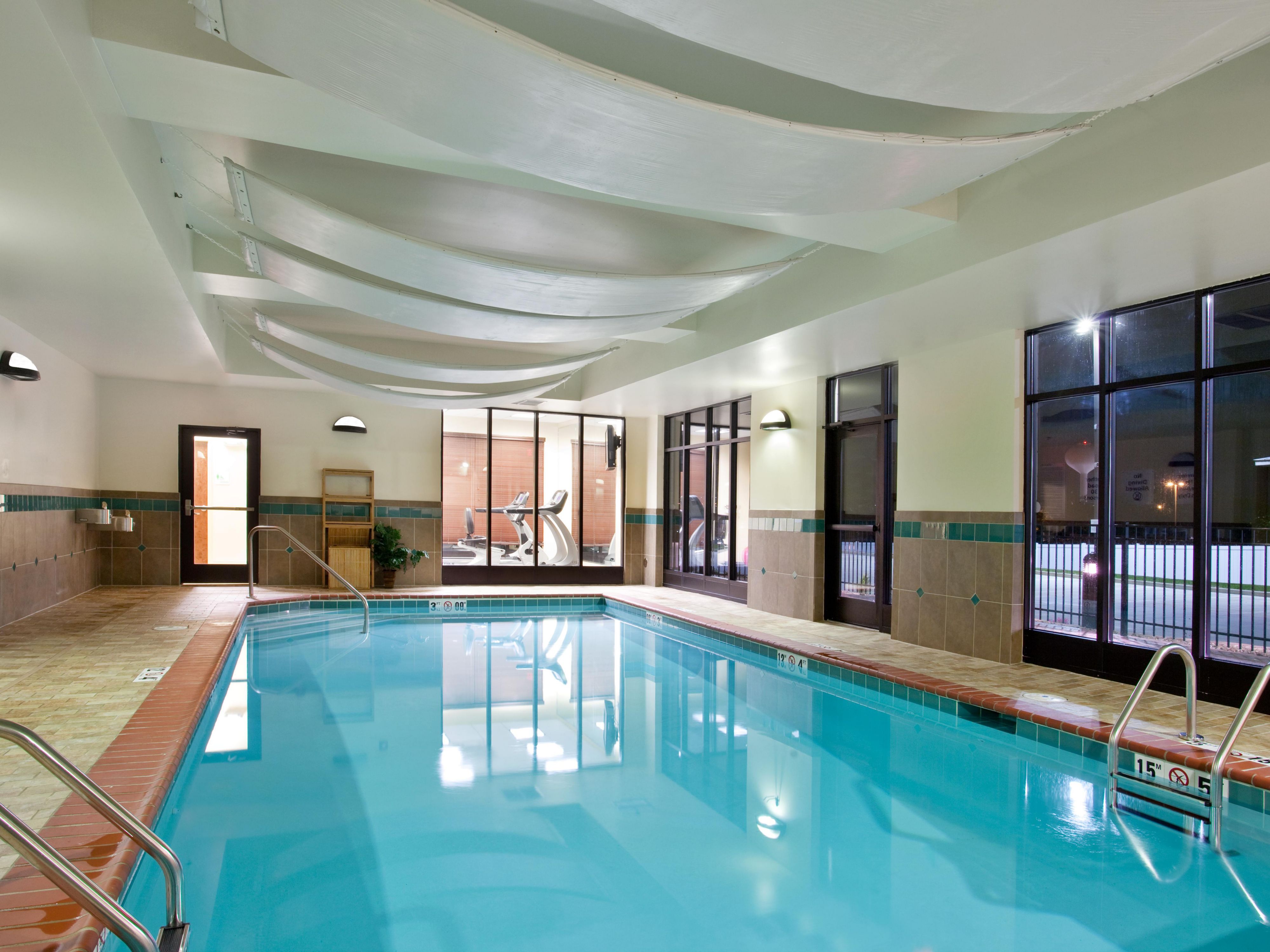 The hotel’s extensive amenities are designed to enhance productivity, relaxation, and convenience. Guests can unwind in our indoor heated pool featuring a smooth pebble‑style finish.