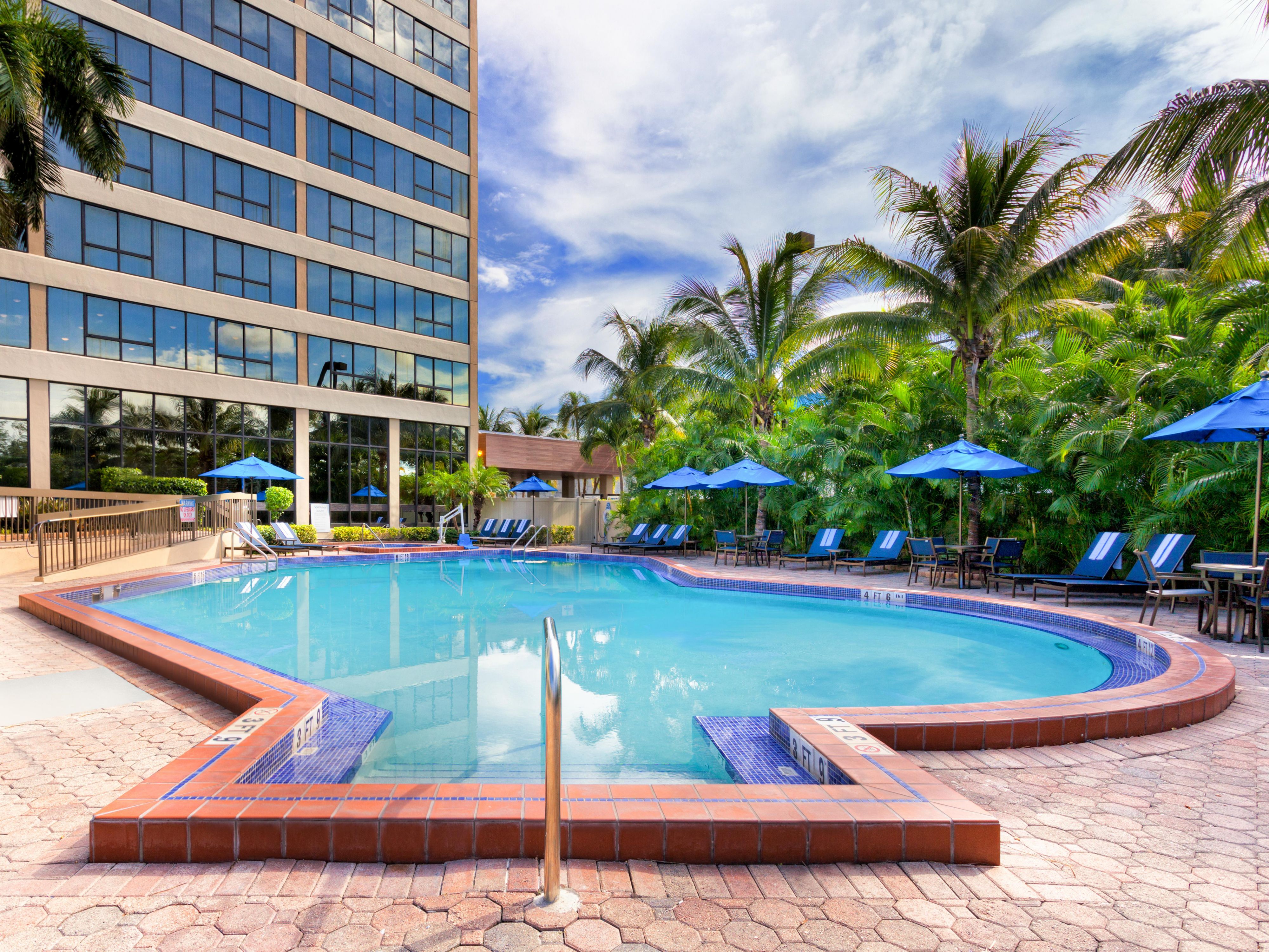 Swim in outdoor pool surrounded by tropical palm trees. 