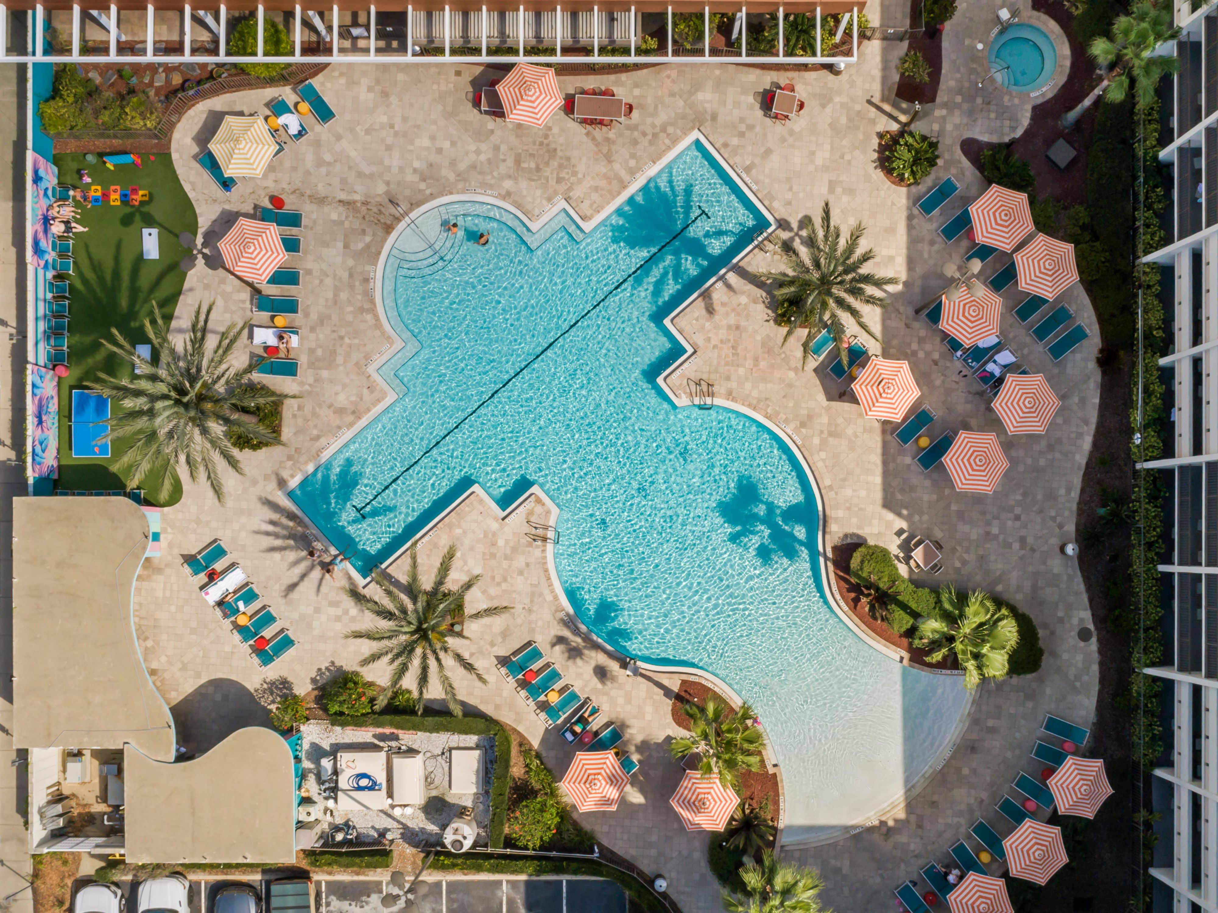 Relax in our tropical oasis, featuring a zero-entry heated swimming pool with a designated lap lane. Enjoy the soothing hot tub, surrounded by plenty of chairs and umbrellas for your comfort. Whether you’re swimming, soaking, or simply lounging, it’s the ideal spot to unwind and soak up the sun!