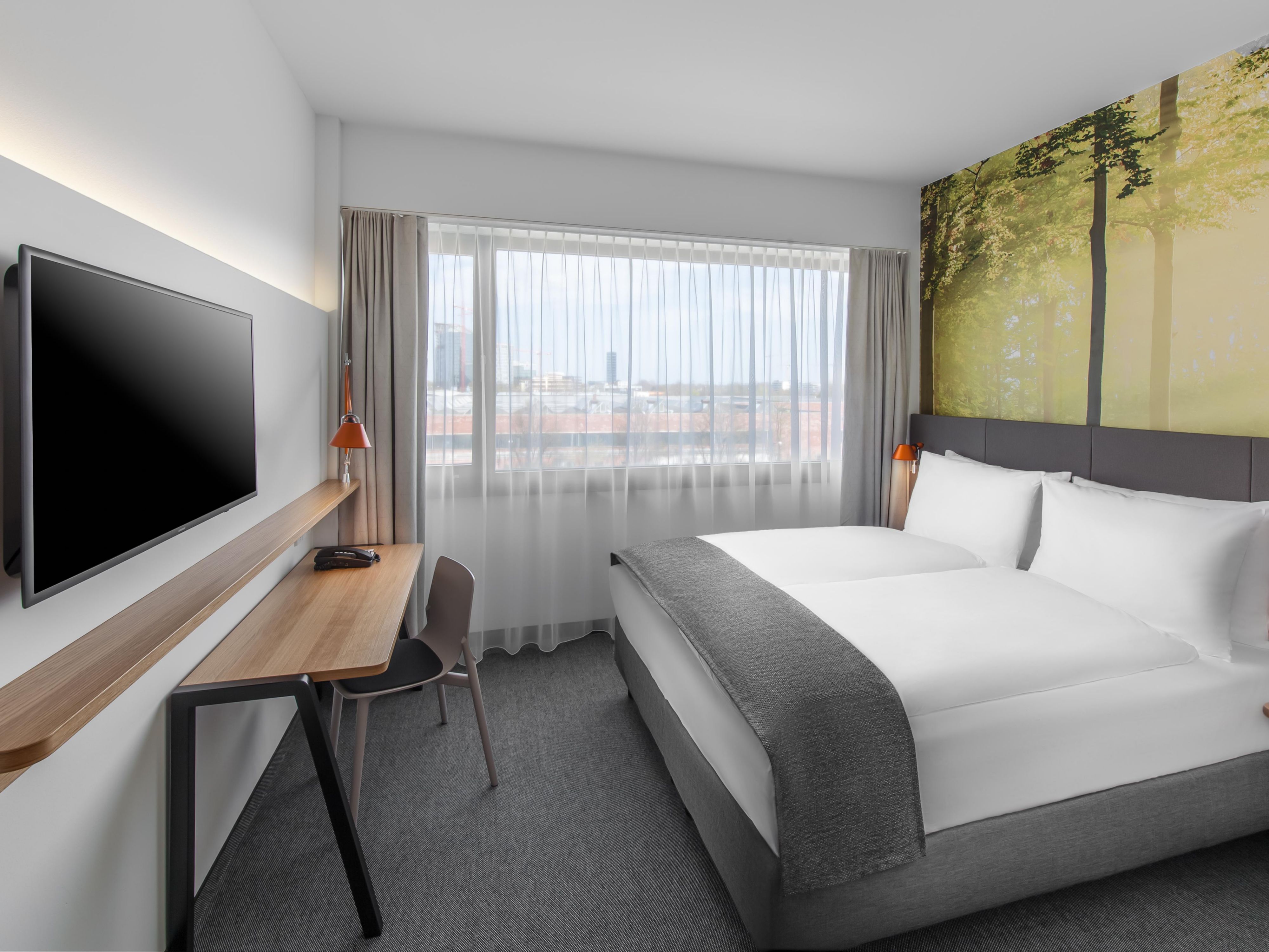 A queen room with warm decor and views over Munich's rooftops.