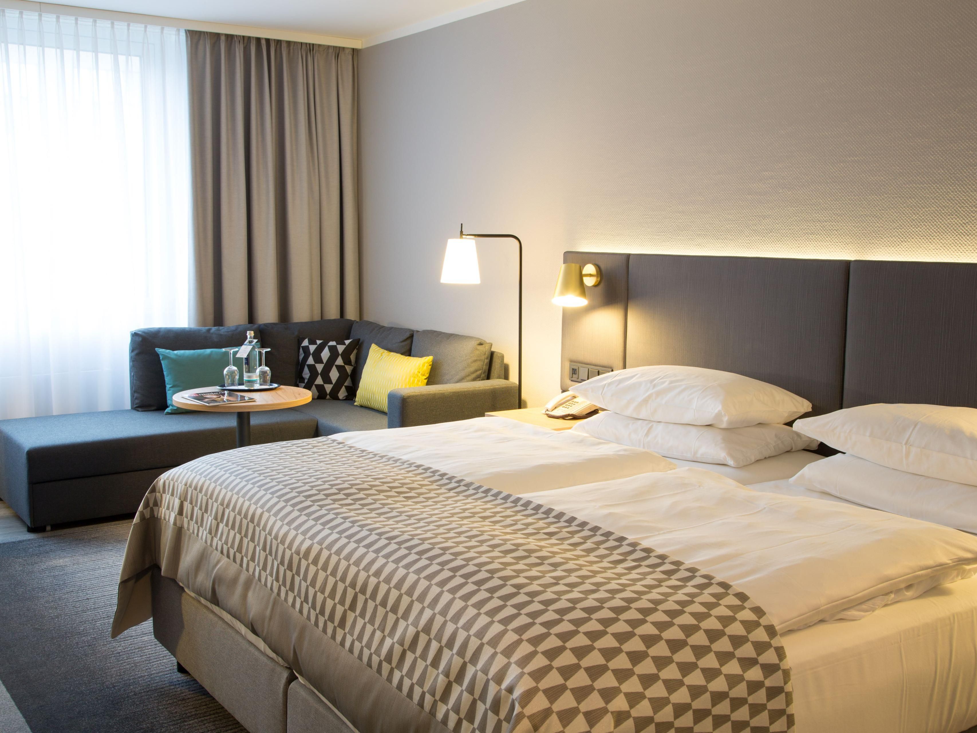 Our timelessly elegant guest rooms welcome you with plenty of space (minimum size 27m²). The coffee and tea bar is just as much a part of it here as a modern workstation, a corner sofa as a cozy resting zone as well as our Holiday Inn pillow menu for your personal comfort.