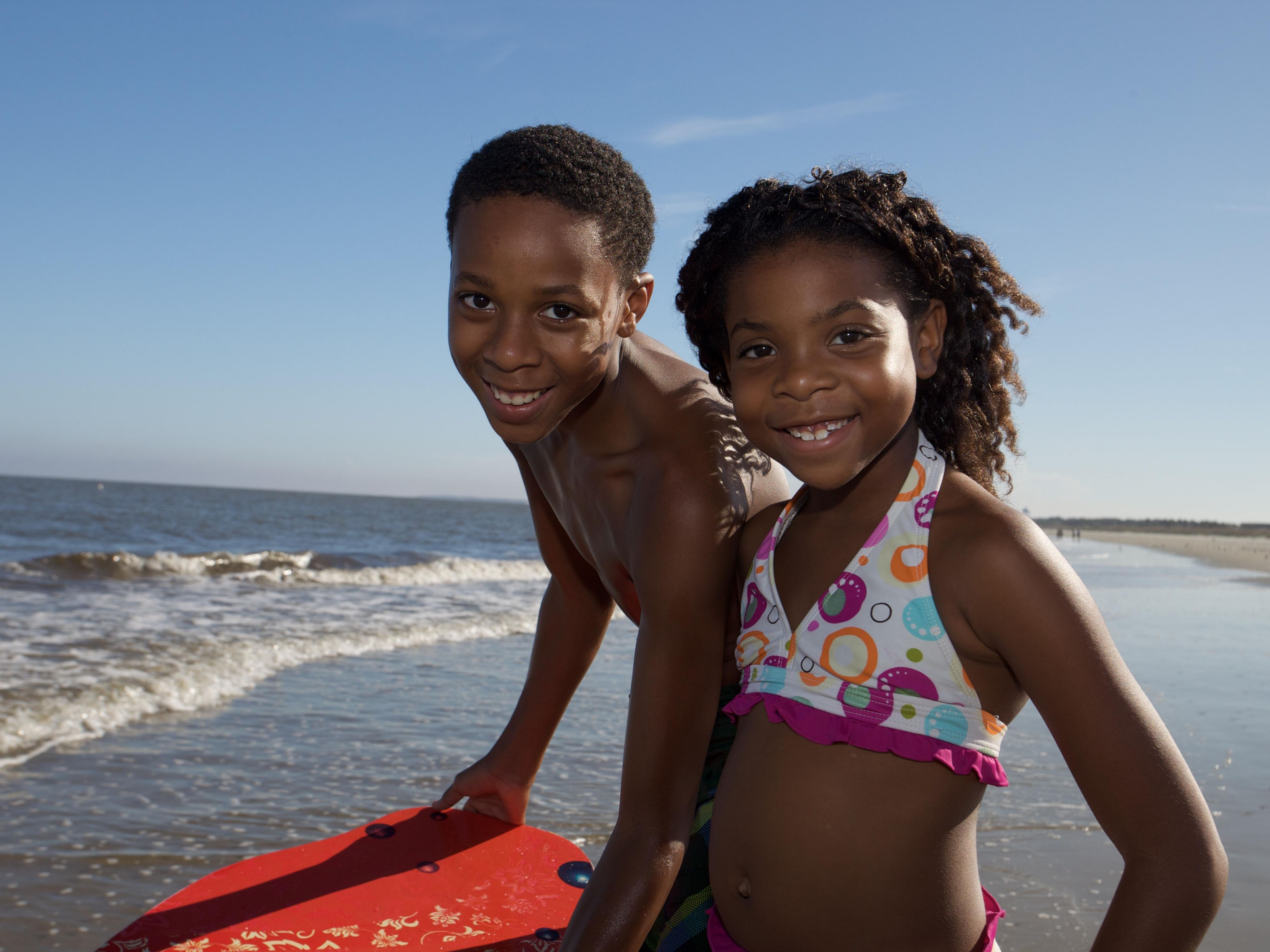 Boy and girl going to swim in ocean