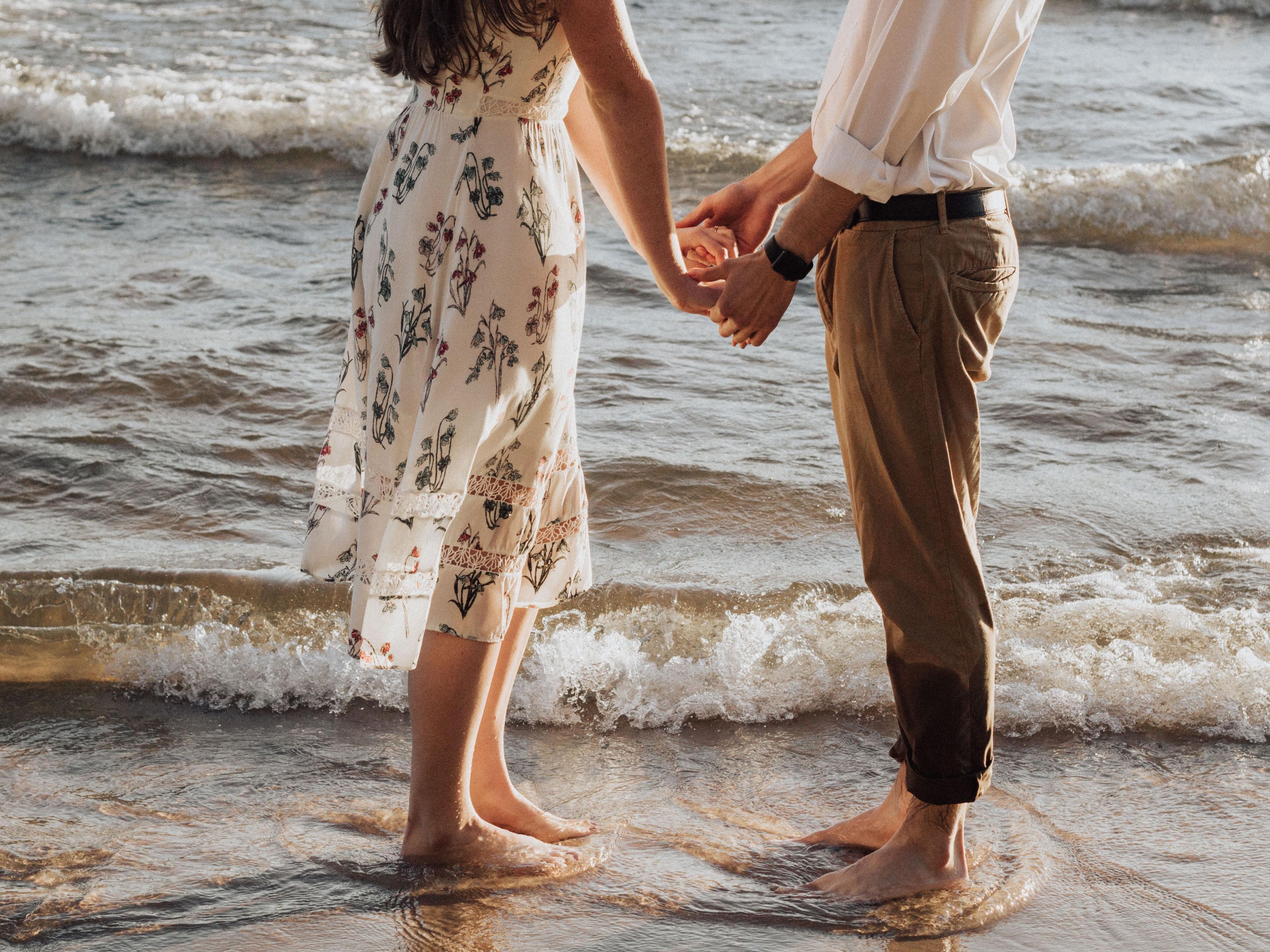 Couple holding hands in waves