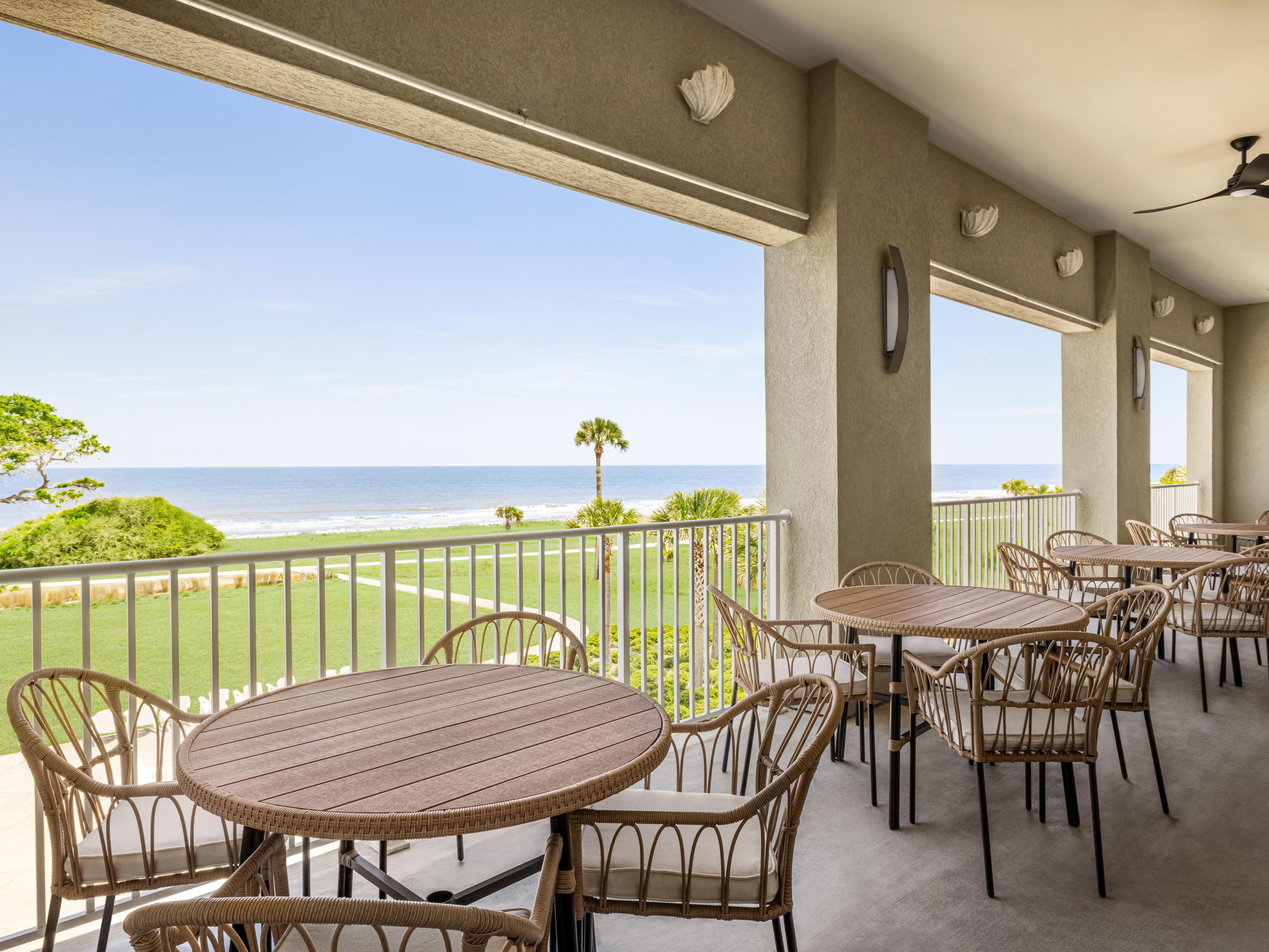 Balcony with tables and chairs facing the ocean